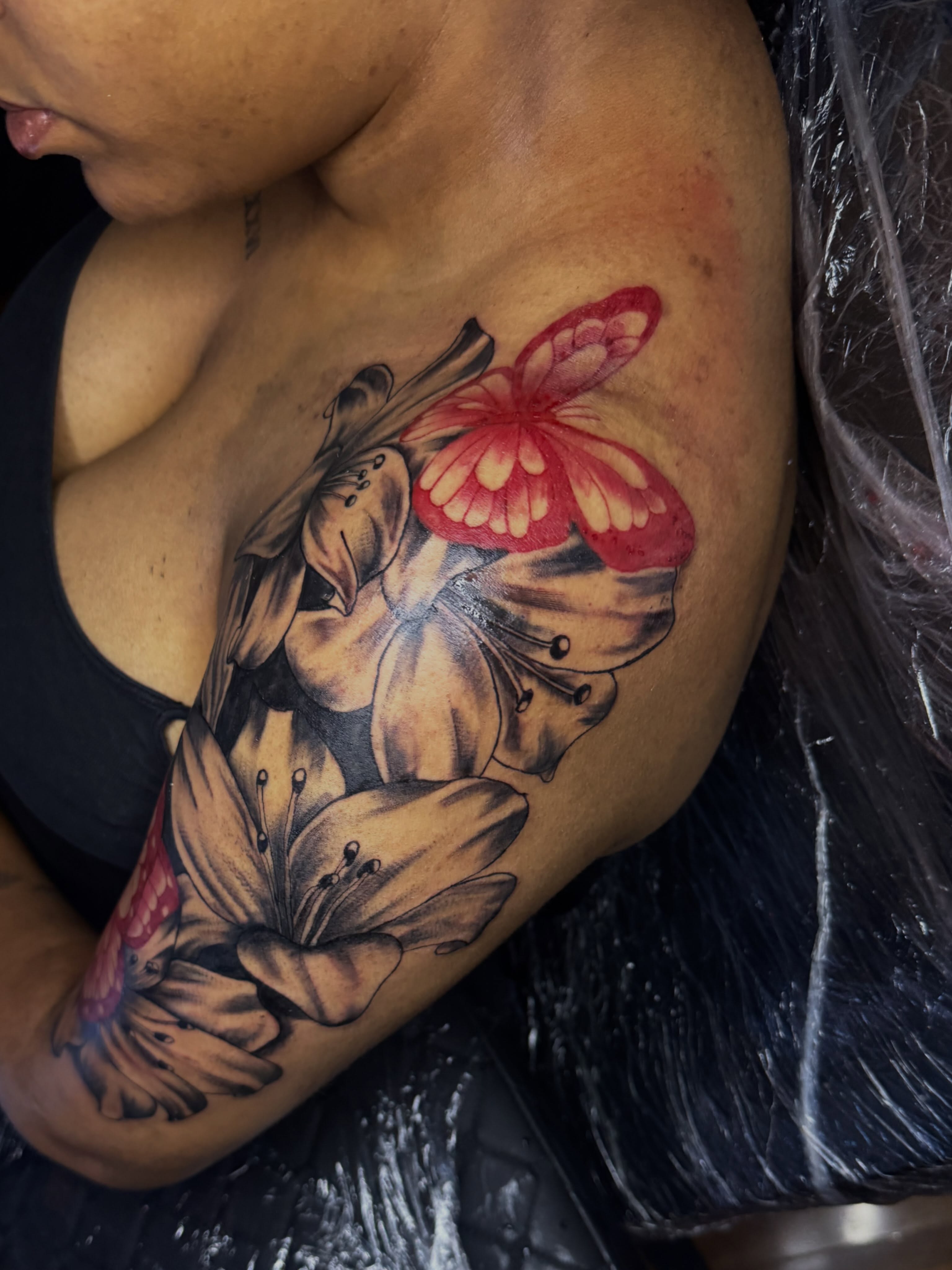 Lilies and butterfly realism tattoo on the shoulder by Tcstatts