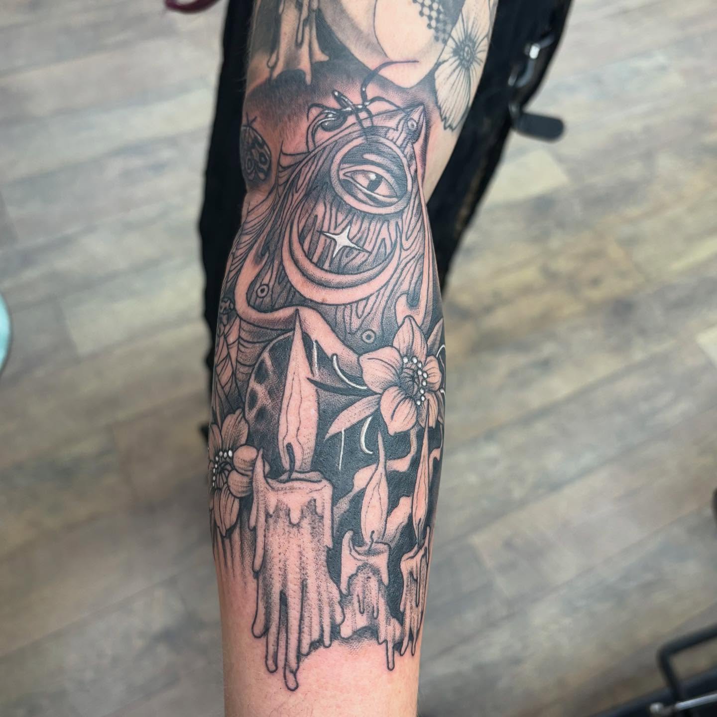 Candles and flowers black and grey tattoo on the forearm by Robbie Reel, Wichita, Kansas