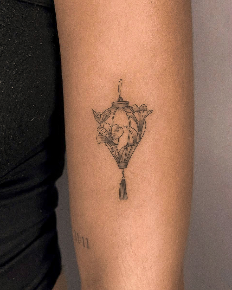 Lantern with flowers minimalist tattoo on the forearm by Richmond tattoo shop, Richmond, Texas