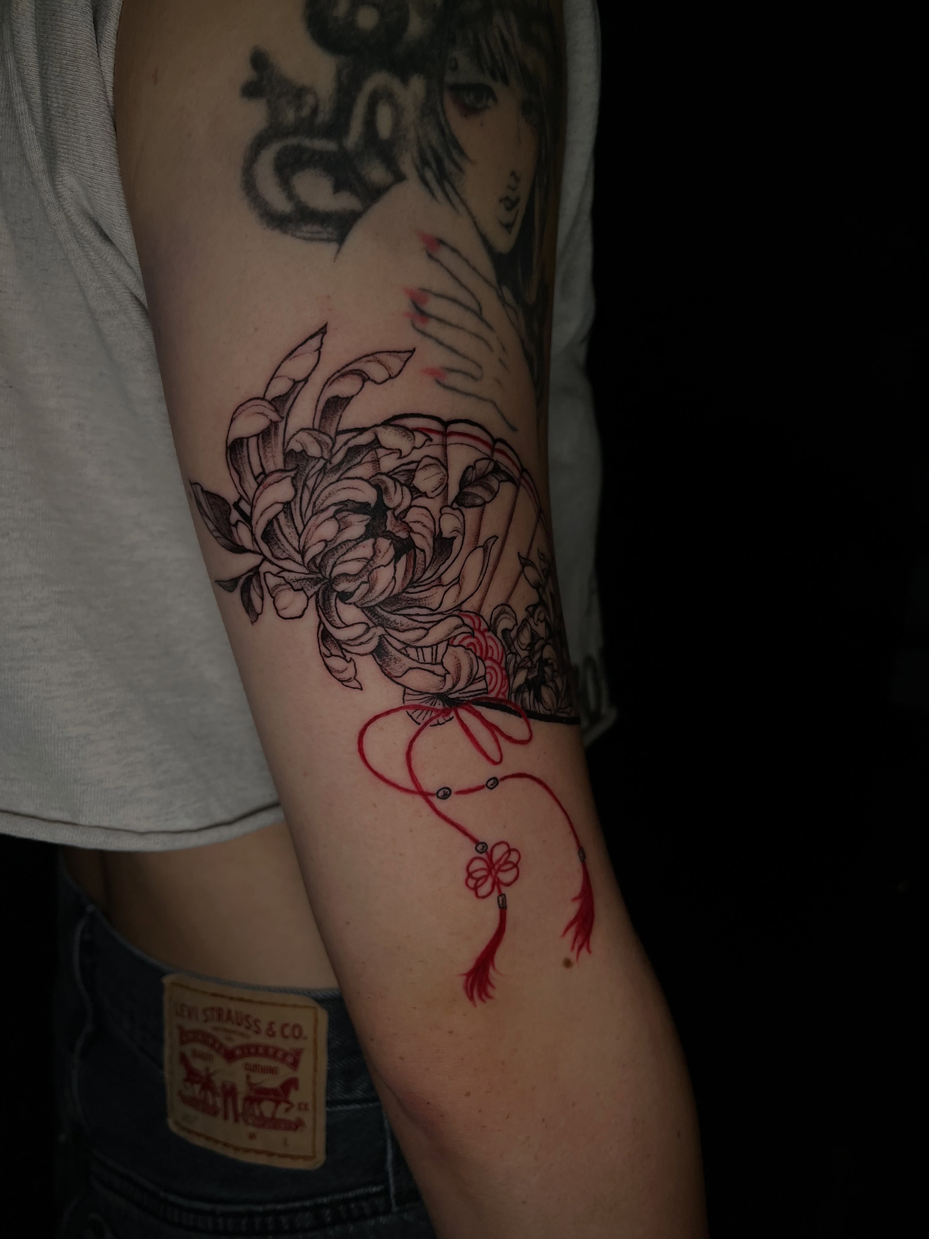 Chrysanthemum and tassel fine line tattoo on the forearm by bev