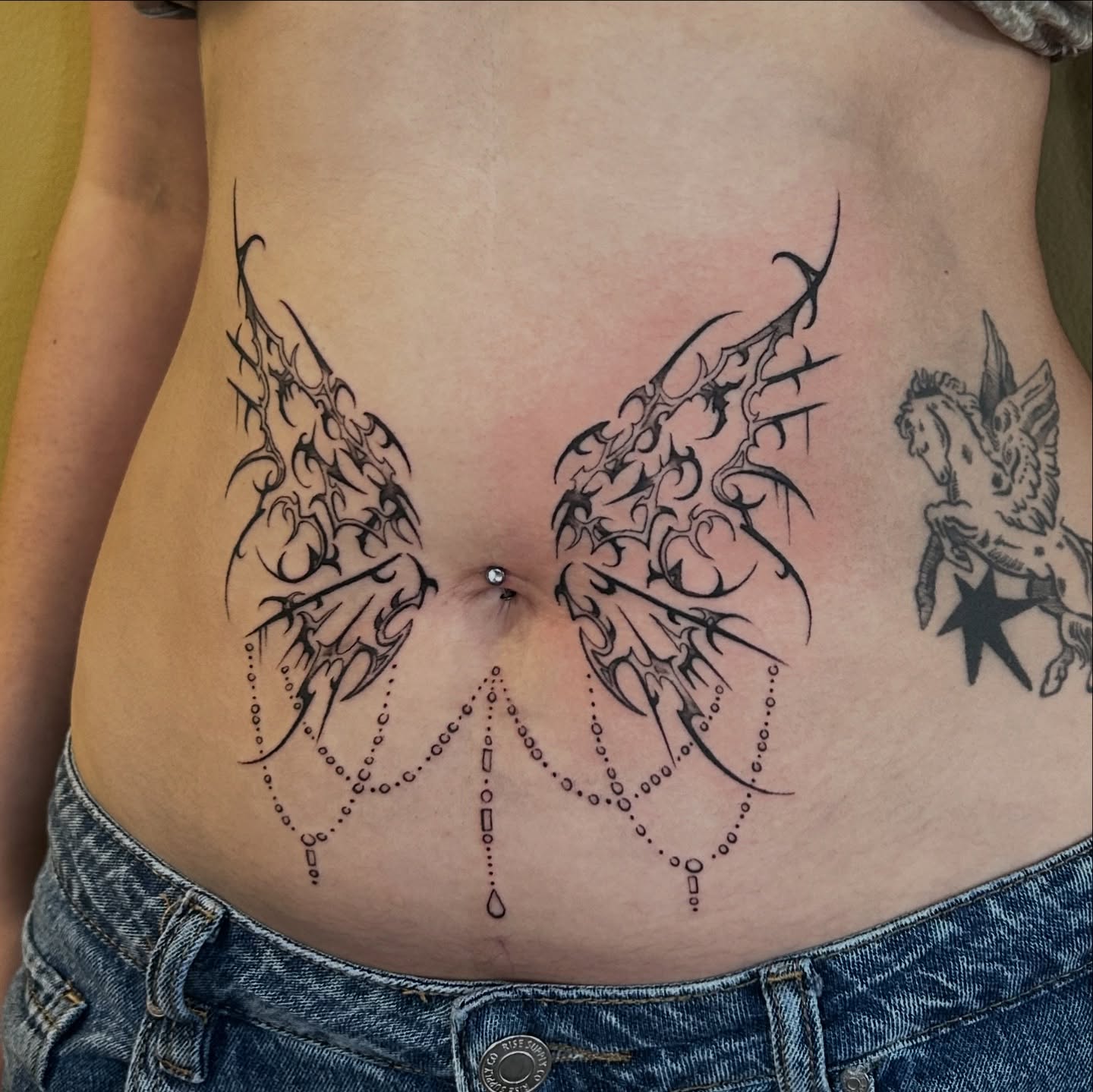 Wings tribal tattoo on the torso by Cassy D, Miami, Florida
