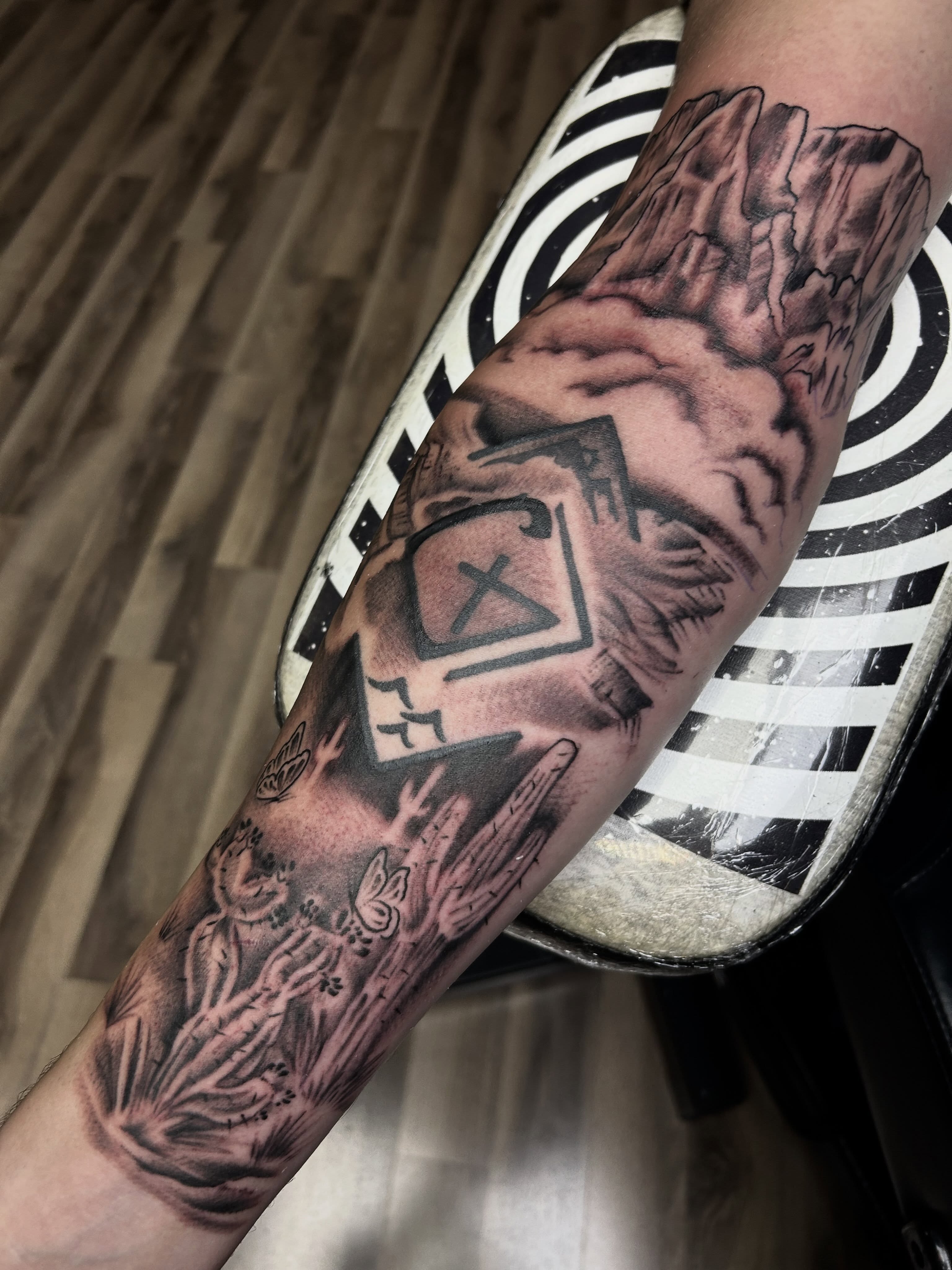 Landscape with cacti realism tattoo on the forearm by Dan Schuster