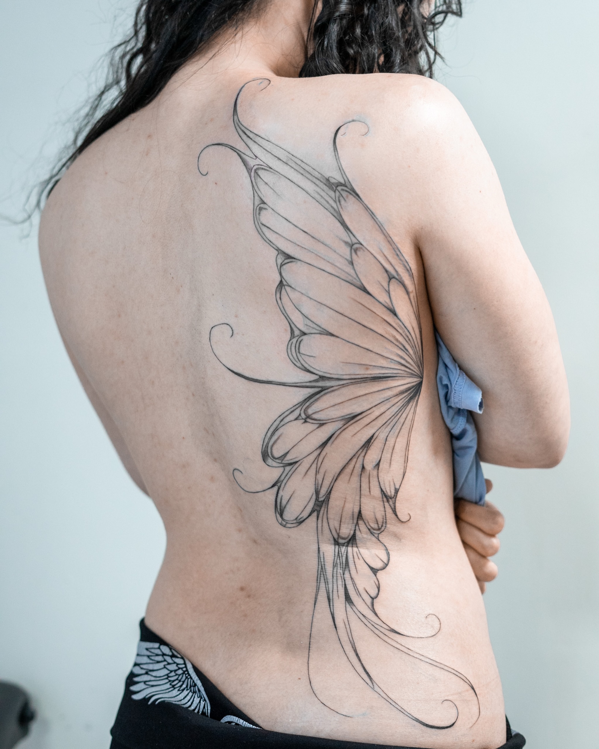 Wing black and grey tattoo on the back by The Tattoo Plug