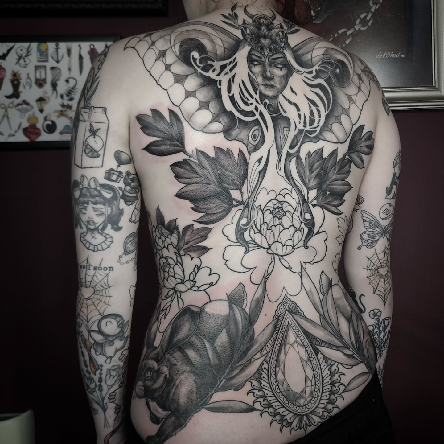 Woman with snake and flowers American traditional tattoo on the back by Arthur Whitney Shail