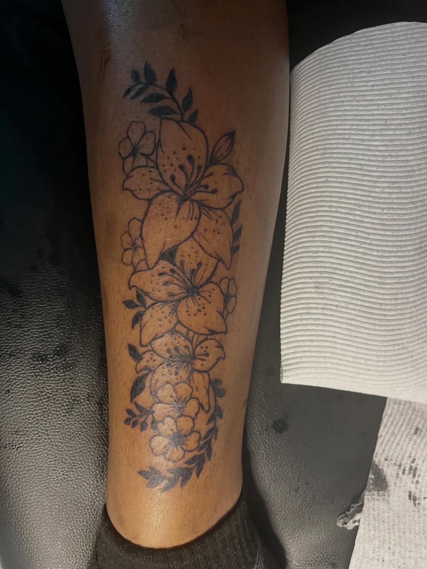 Lilies and blossoms black and grey tattoo on the calf by π Westside