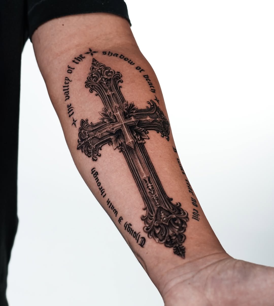 Ornate cross with scripture realism tattoo on the forearm by Enrique Martinez