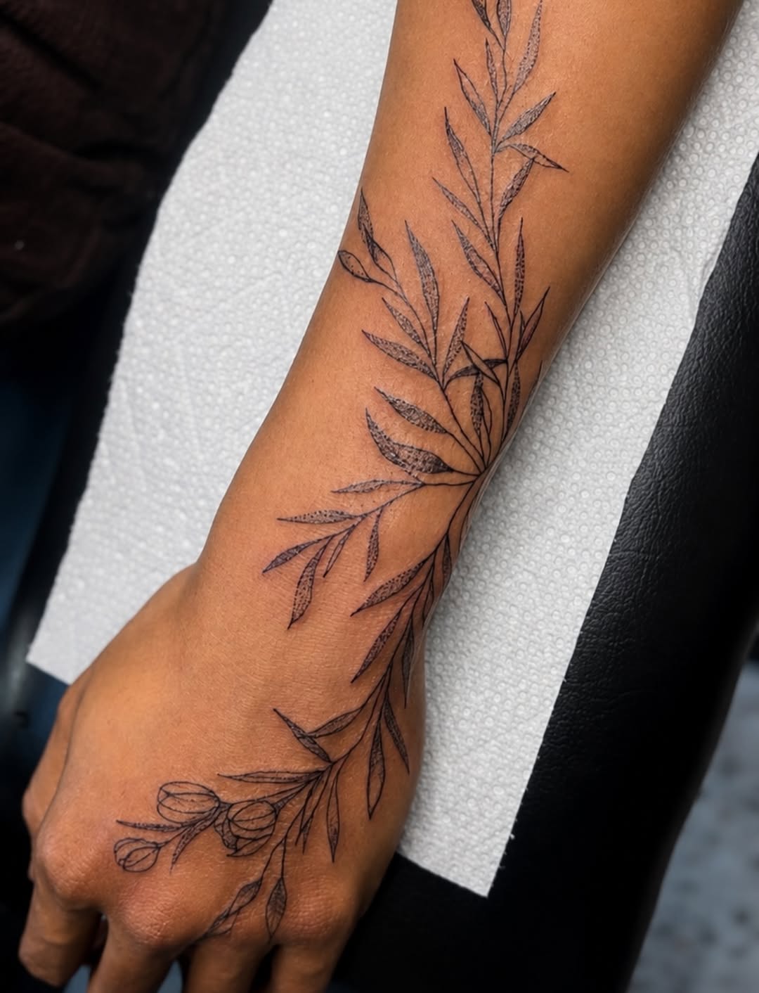 Botanical branch with leaves and buds fine line tattoo on the forearm by Cece, Las Vegas, Nevada