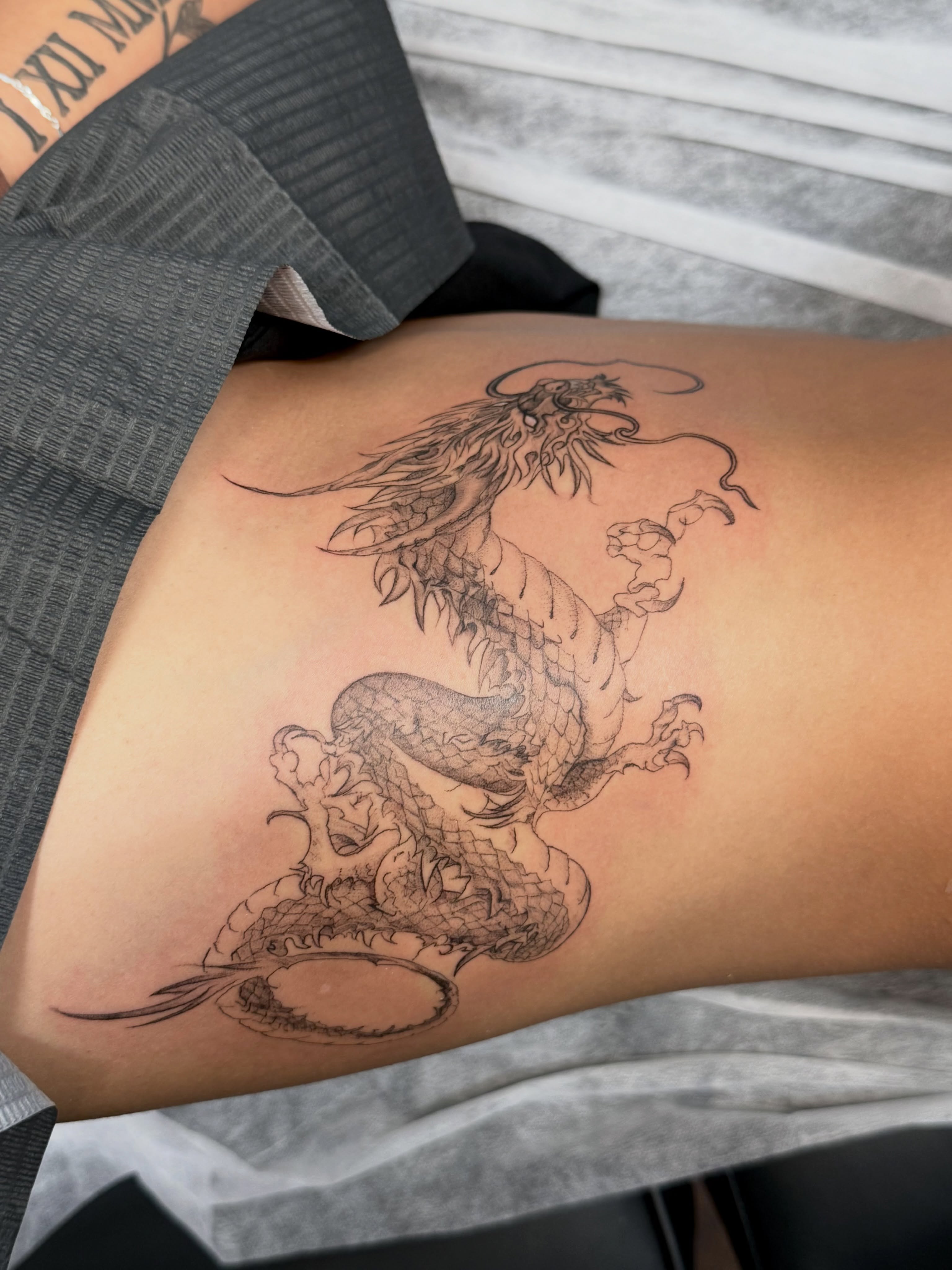 Dragon black and grey tattoo on the thigh by Ava De La Torre