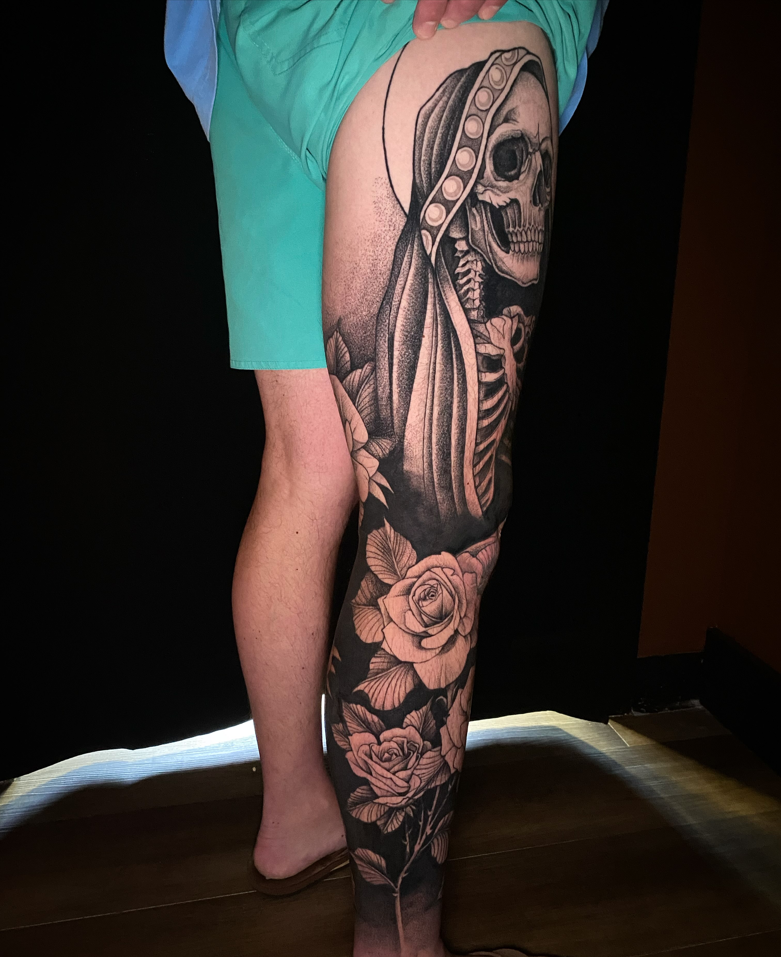 Skeleton with roses dotwork tattoo on the calf by Casey Dohner