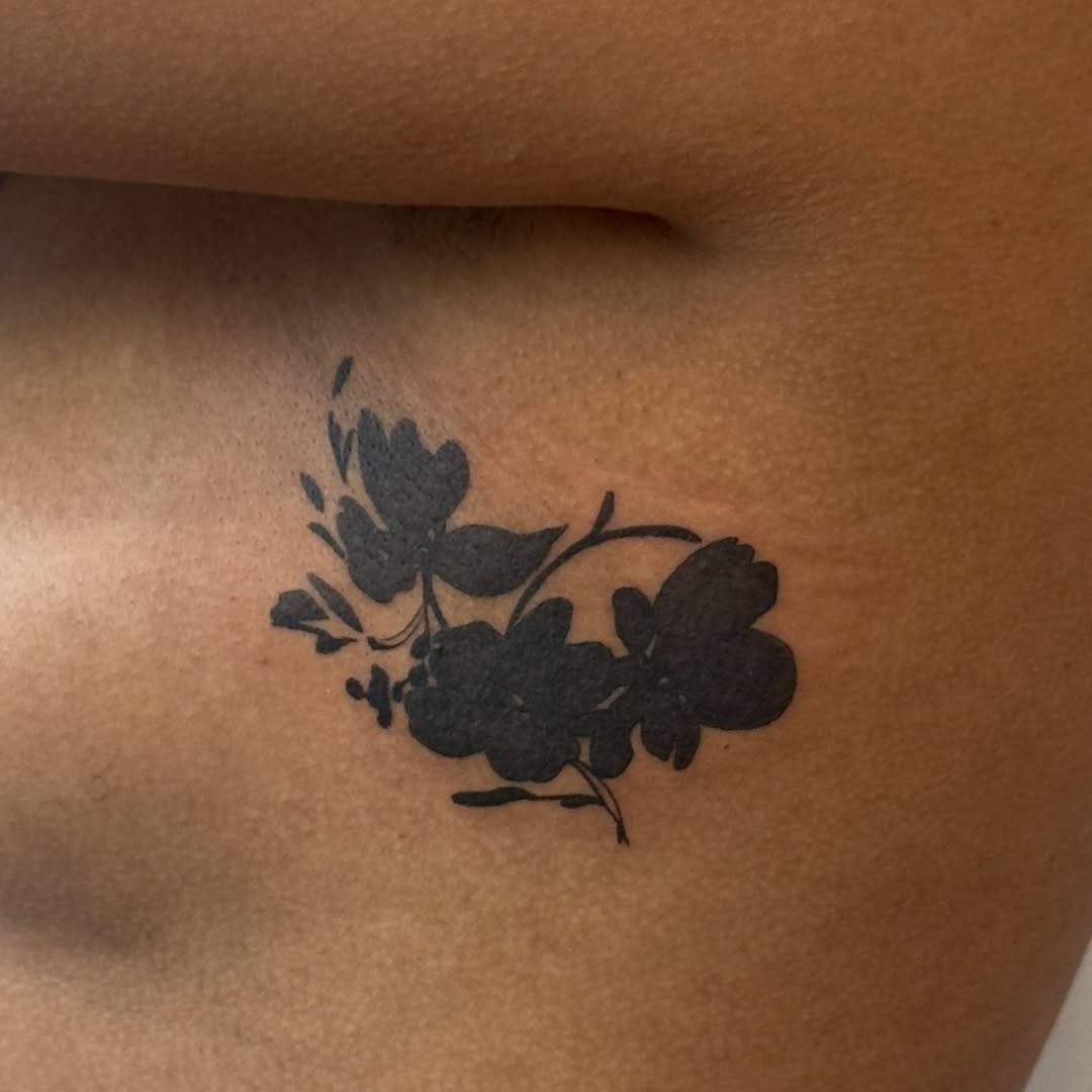 Floral silhouette fine line tattoo on the chest by Kirsten