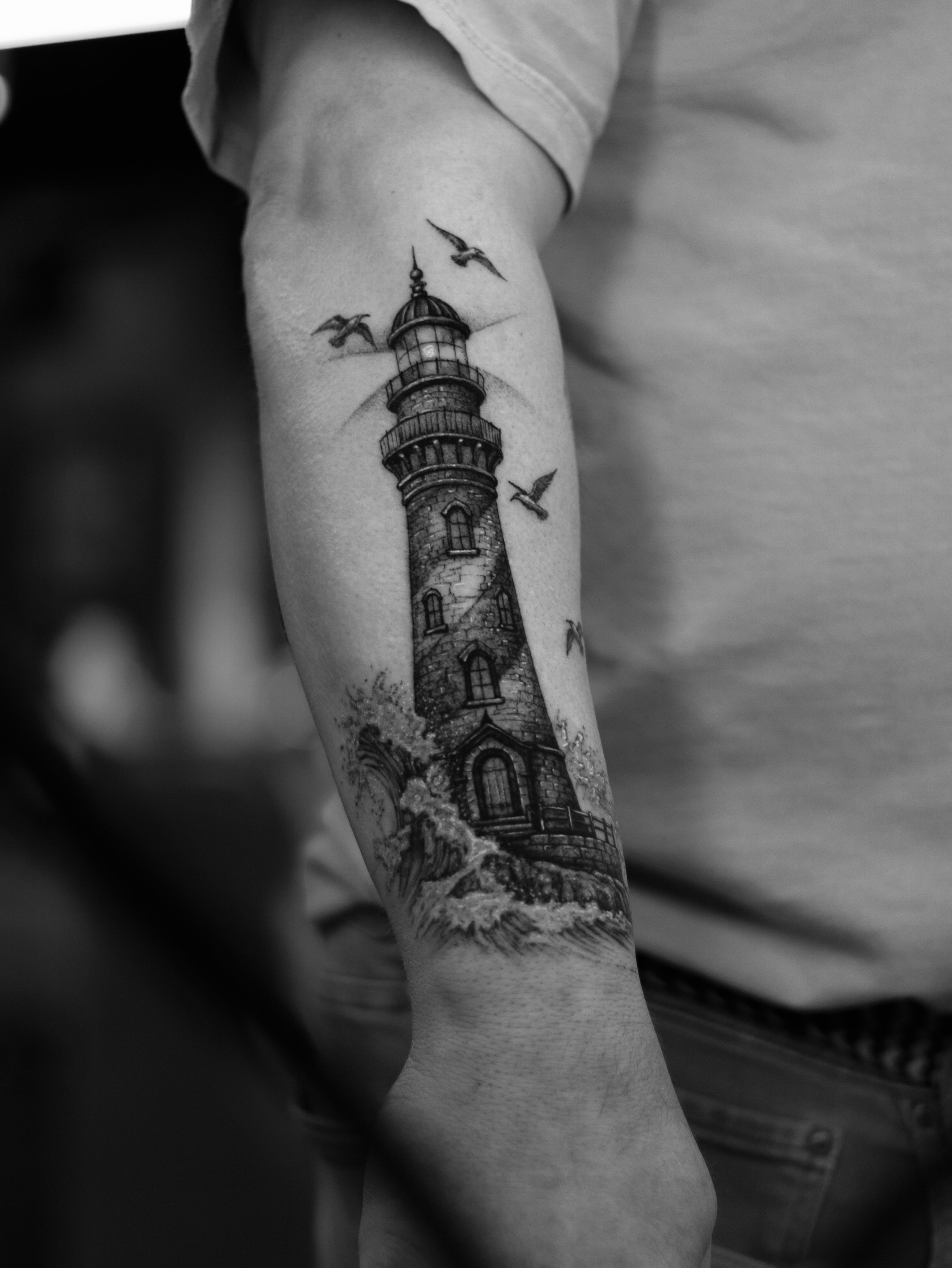 Lighthouse realism tattoo on the forearm by Arthur Kossoski