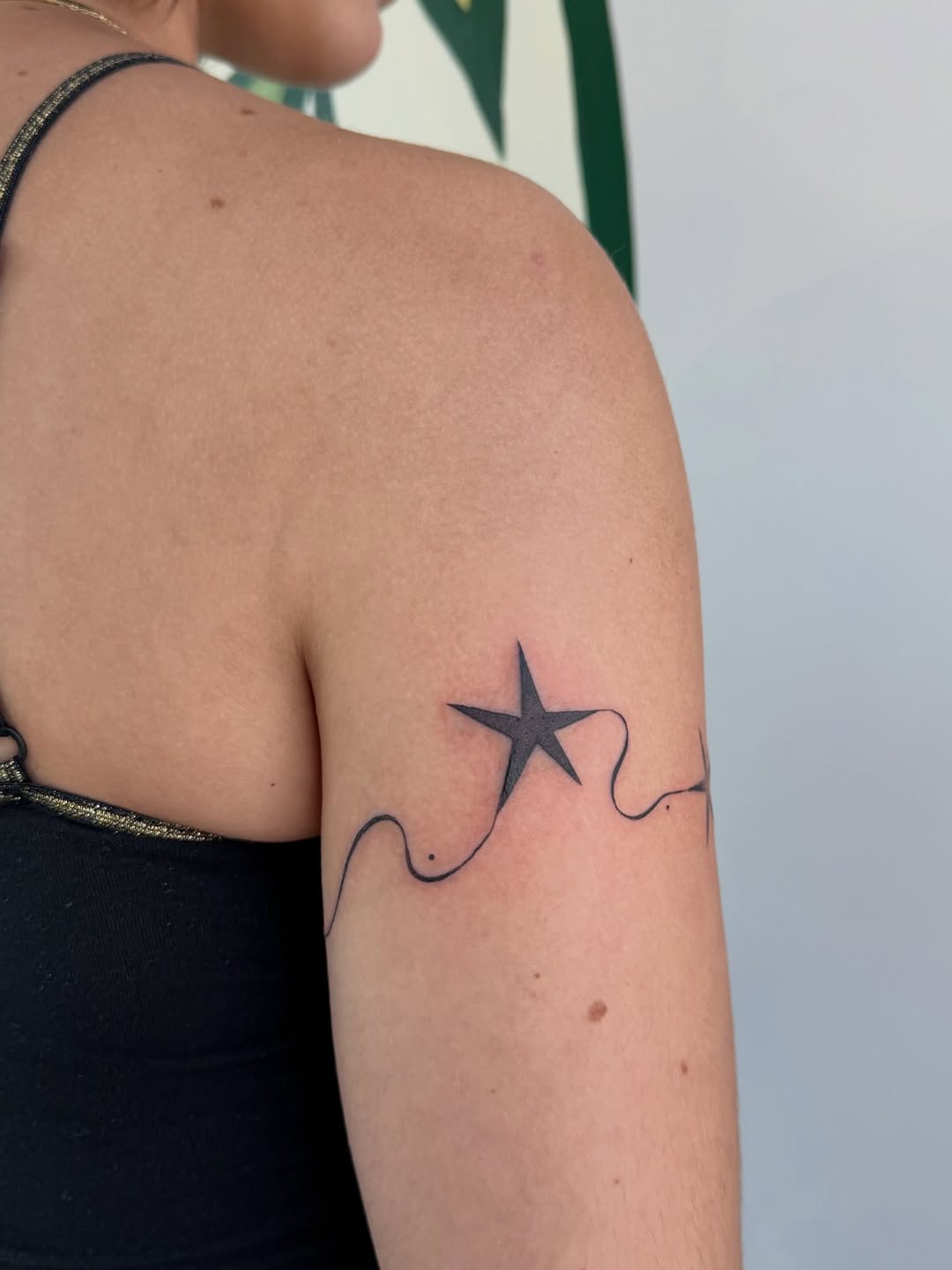 Star and wavy line fine line tattoo on the upper arm by gabrielle rosemary ποΈ