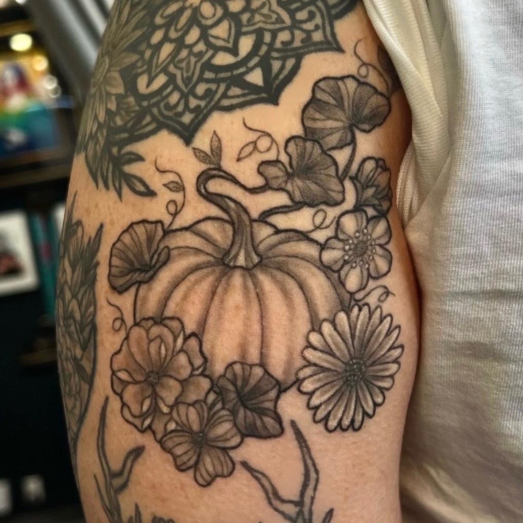 Pumpkin and flowers black and grey tattoo on the forearm by Nikki Malfitano