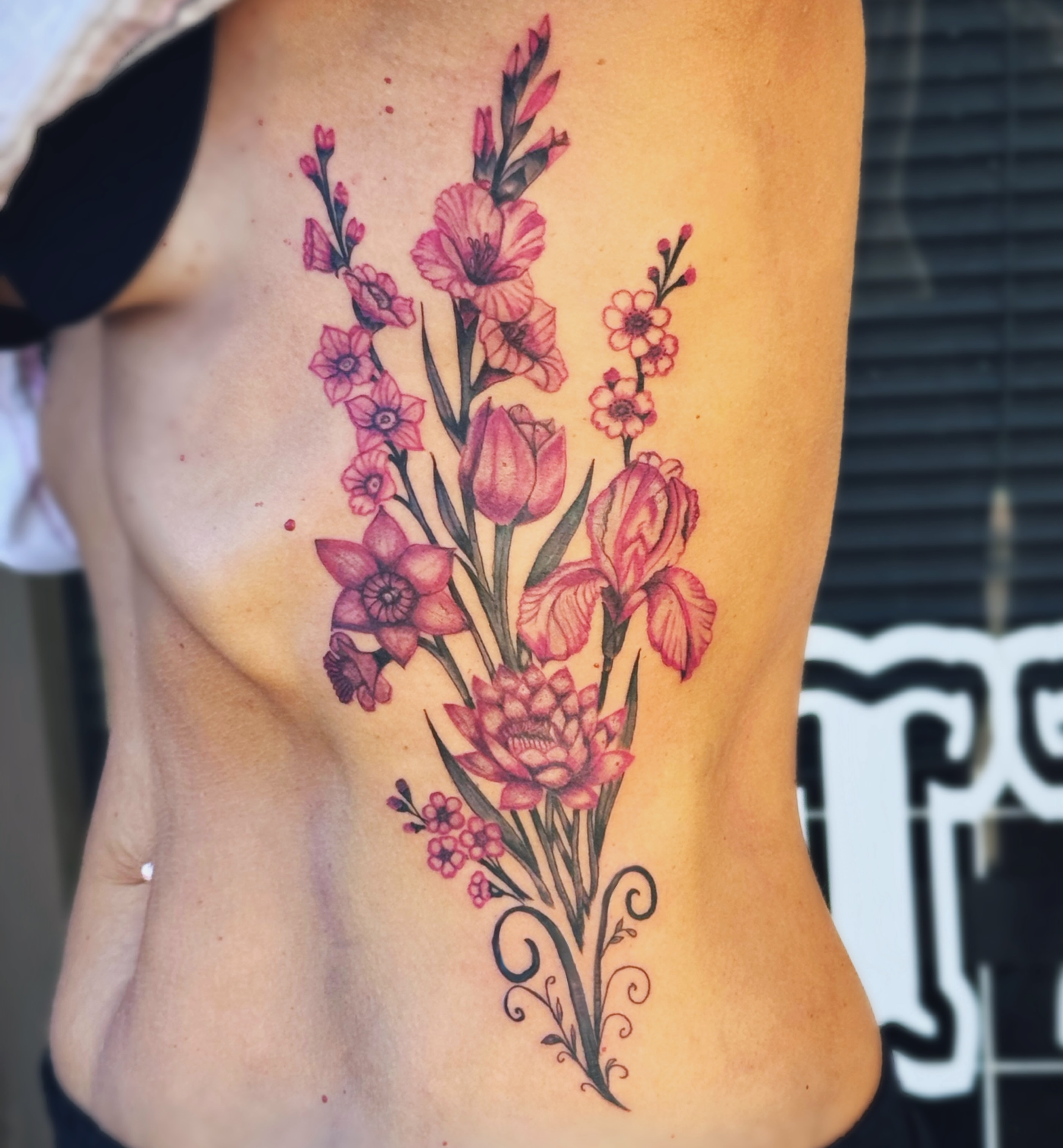 Floral bouquet realism tattoo on the ribs by Kate