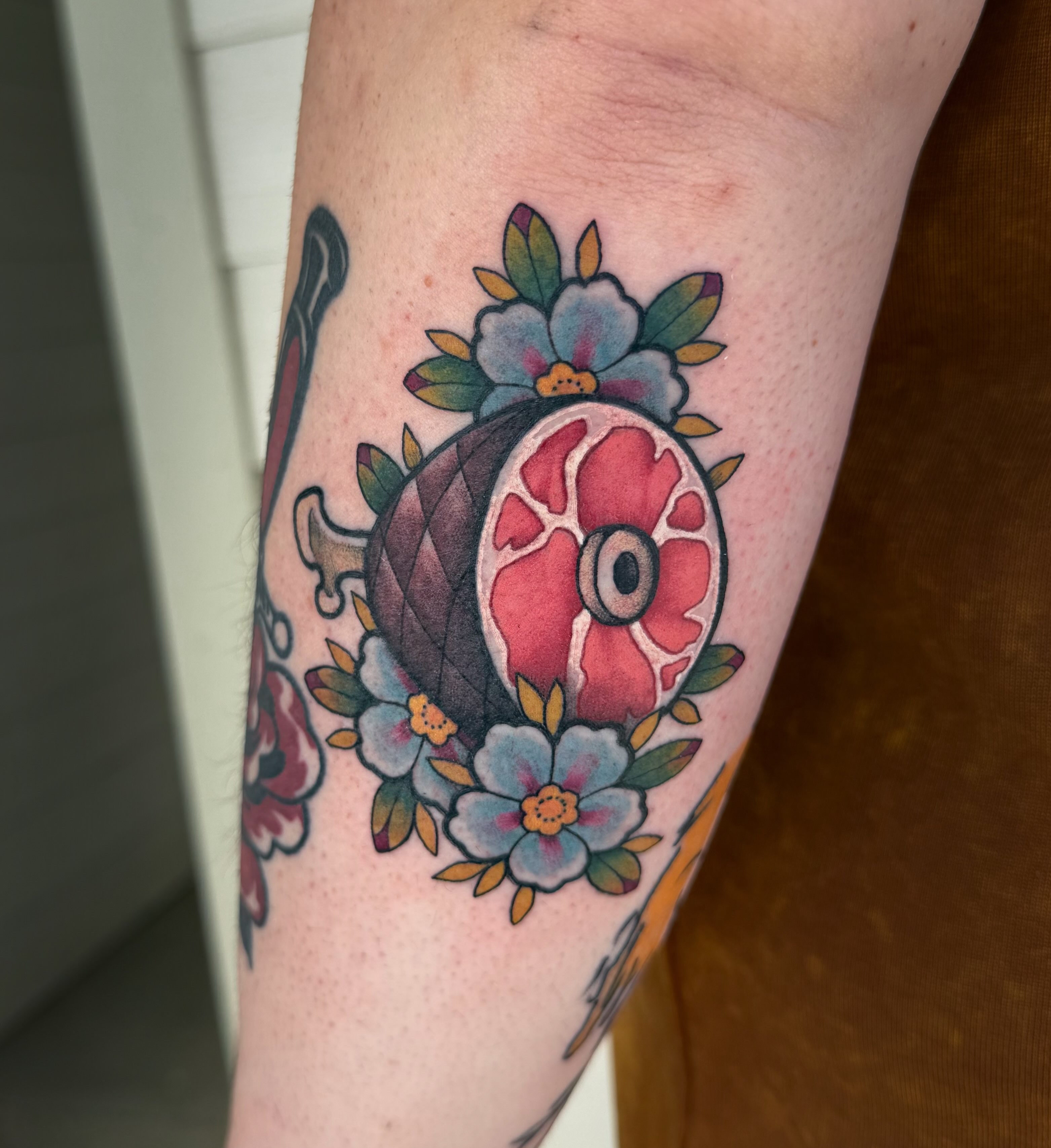 Eye and floral arrangement American traditional tattoo on the forearm by rocky love