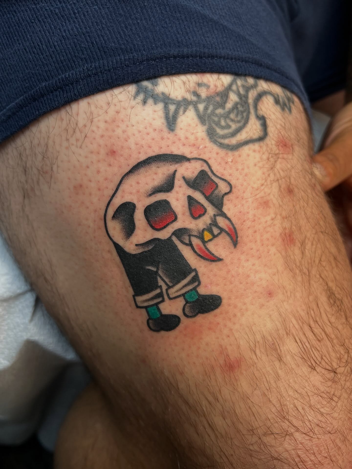 Skull wearing pants American traditional tattoo on the thigh by Tyler Van Pelt