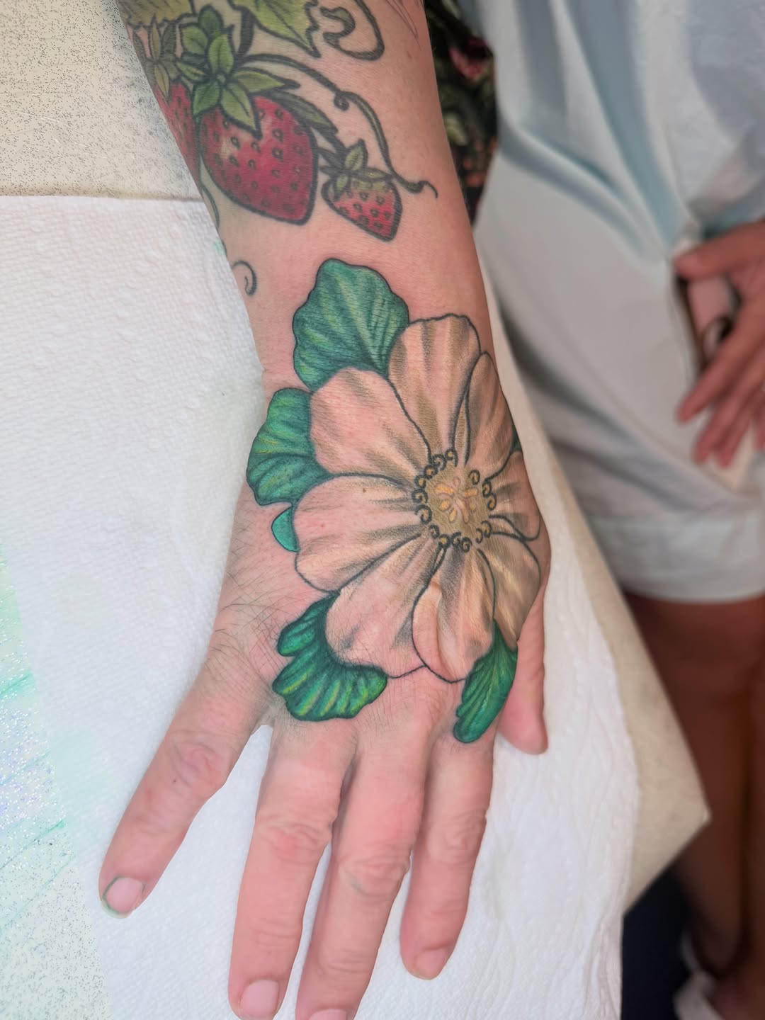 Flower and strawberries neo-traditional tattoo on the hand by Yuri Chloe Ngo Tattoo Artist