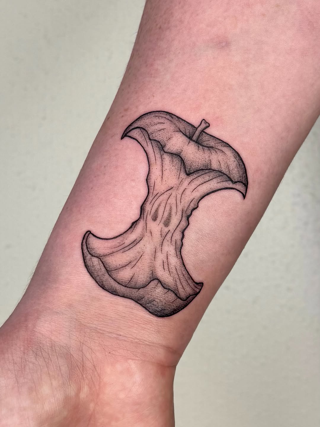 Apple core sketch tattoo on the forearm by Shan