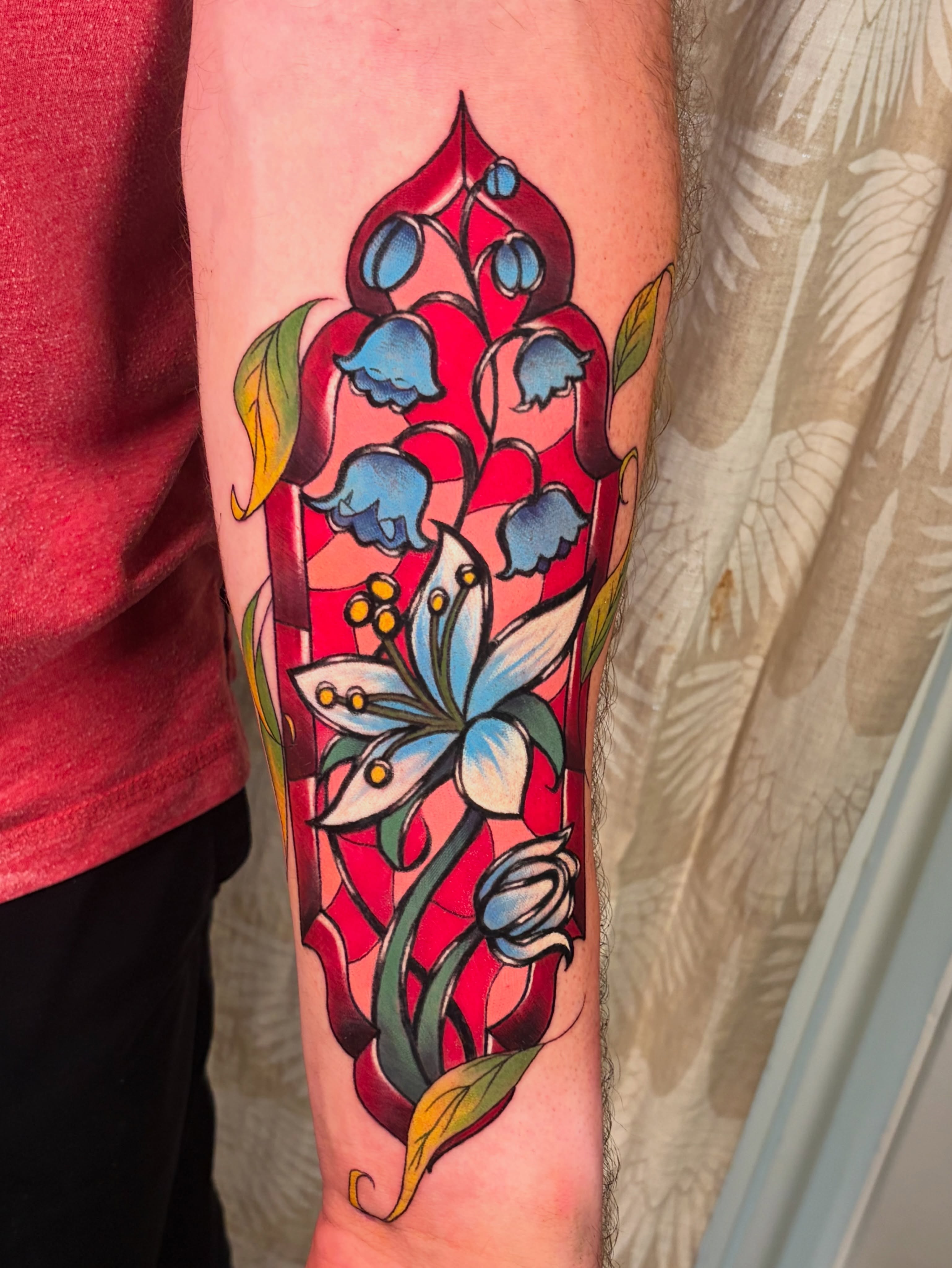 Lily of the valley and lily American traditional tattoo on the forearm by Eva Williams