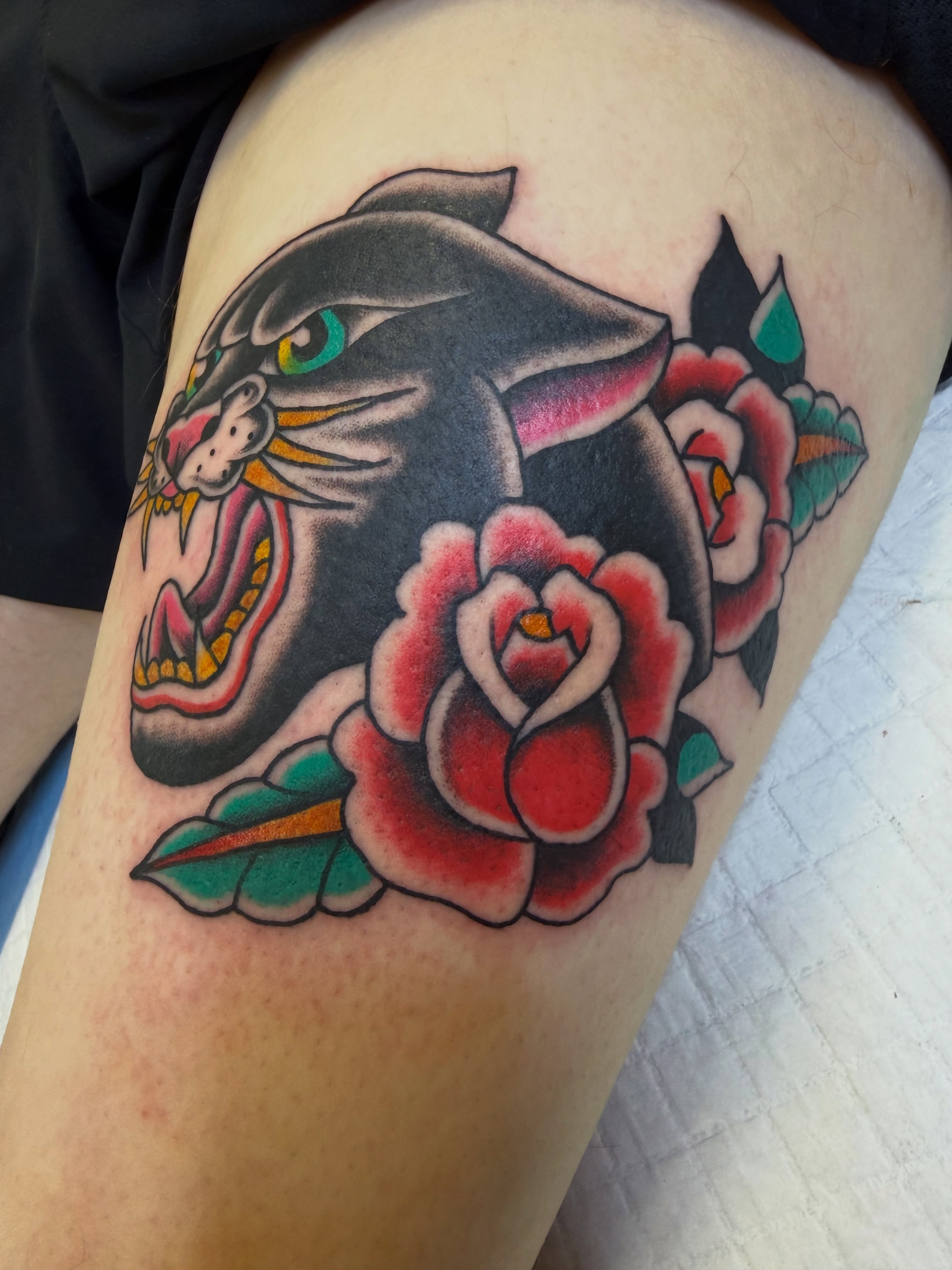 Panther and roses American traditional tattoo on the thigh by Nick Tumminello
