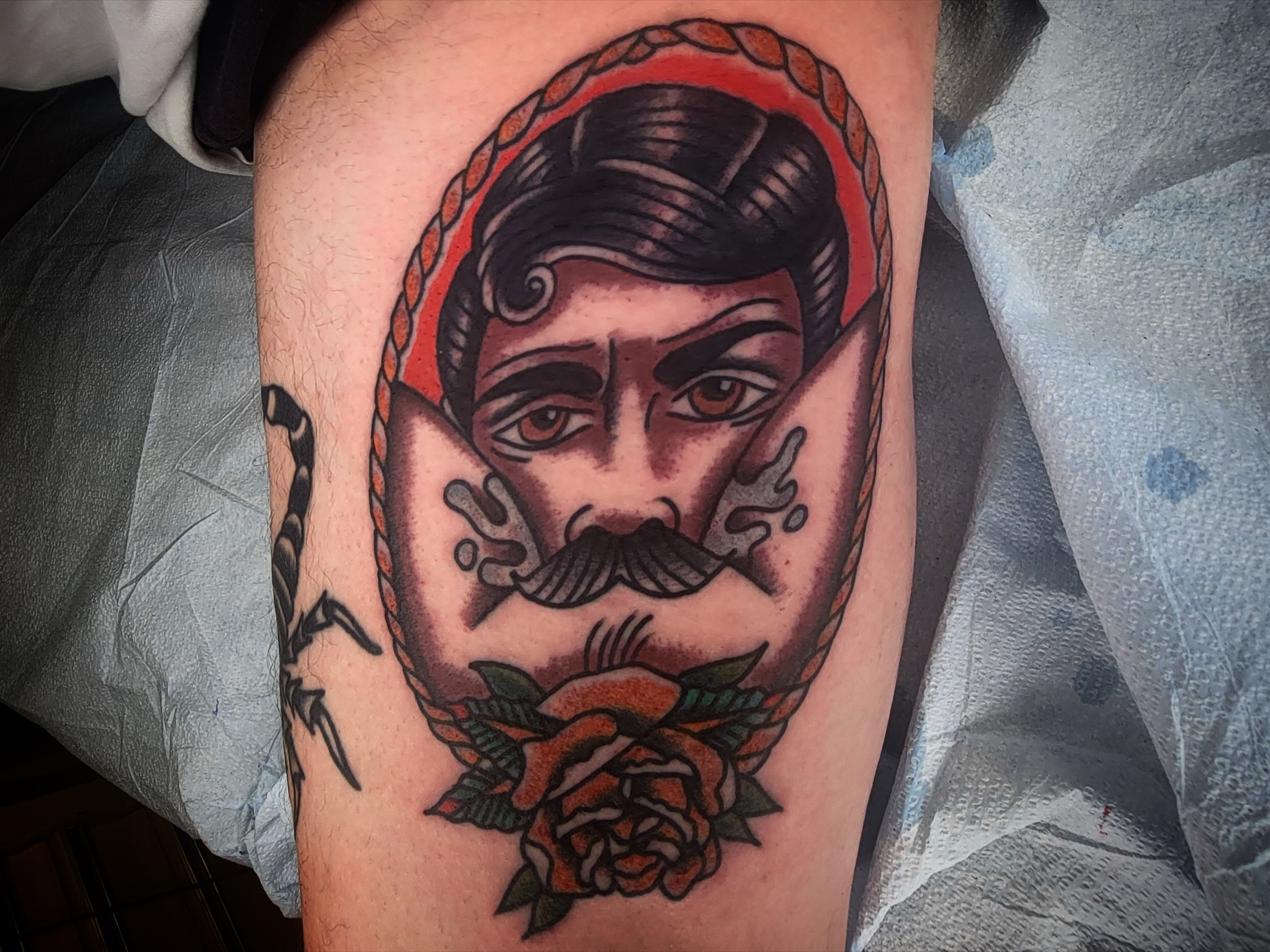 Man with mustache American traditional tattoo on the thigh by joe martinez, Denver, Colorado