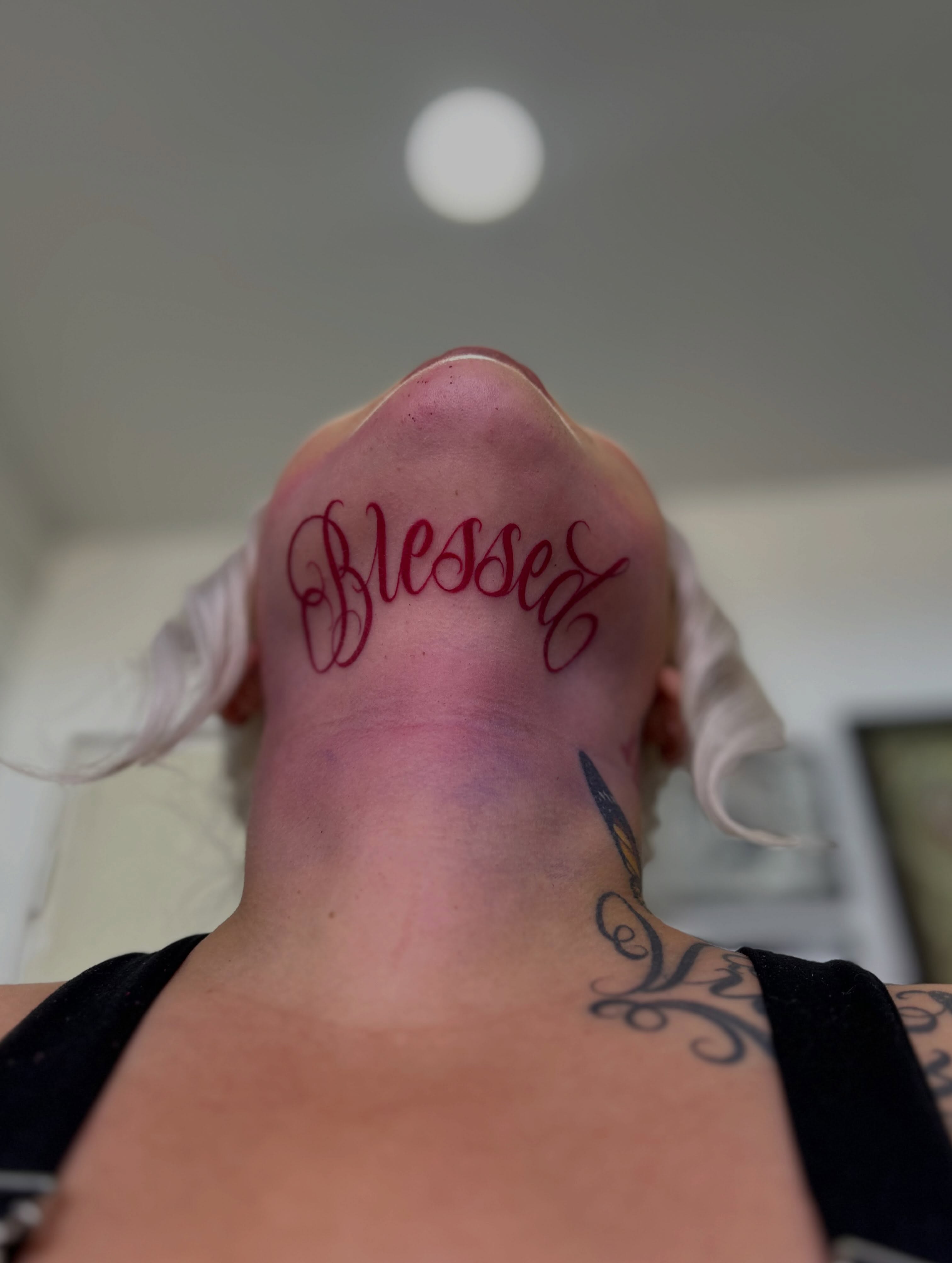 Blessed lettering script tattoo on the neck by Tattoo Artist