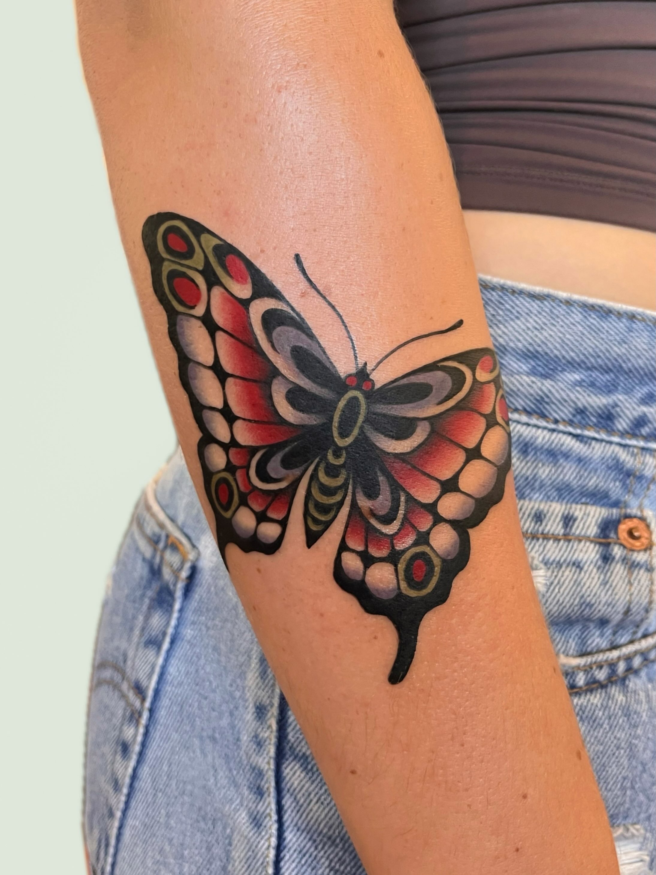 Butterfly new school tattoo on the forearm by nina