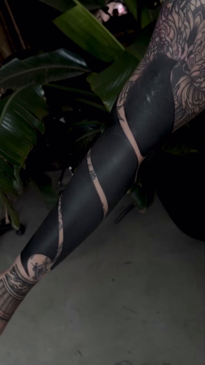 Blackwork sleeve with abstract negative space tribal tattoo on the upper arm by Rachel