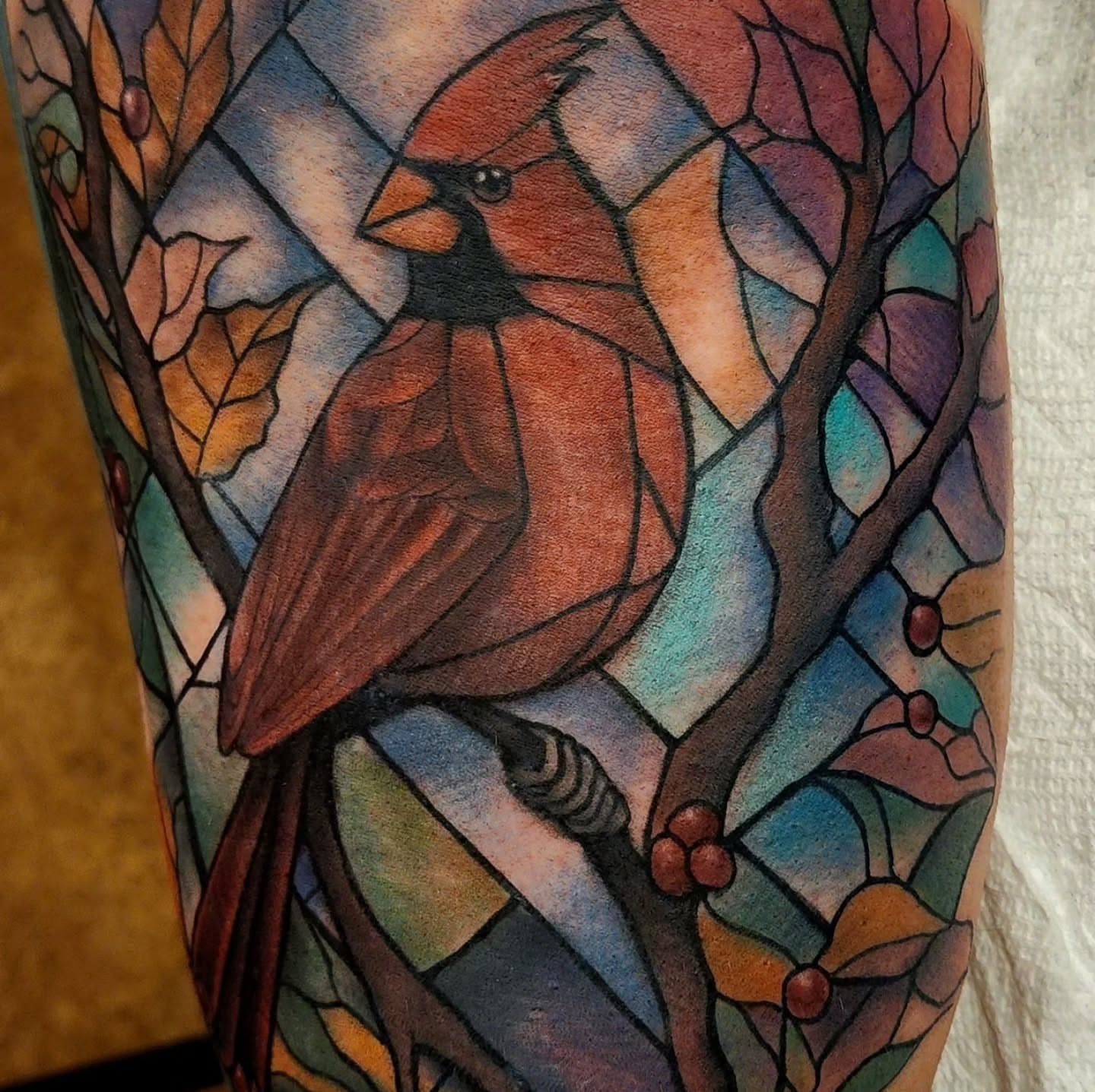 Cardinal bird geometric tattoo on the forearm by Katie Palmer