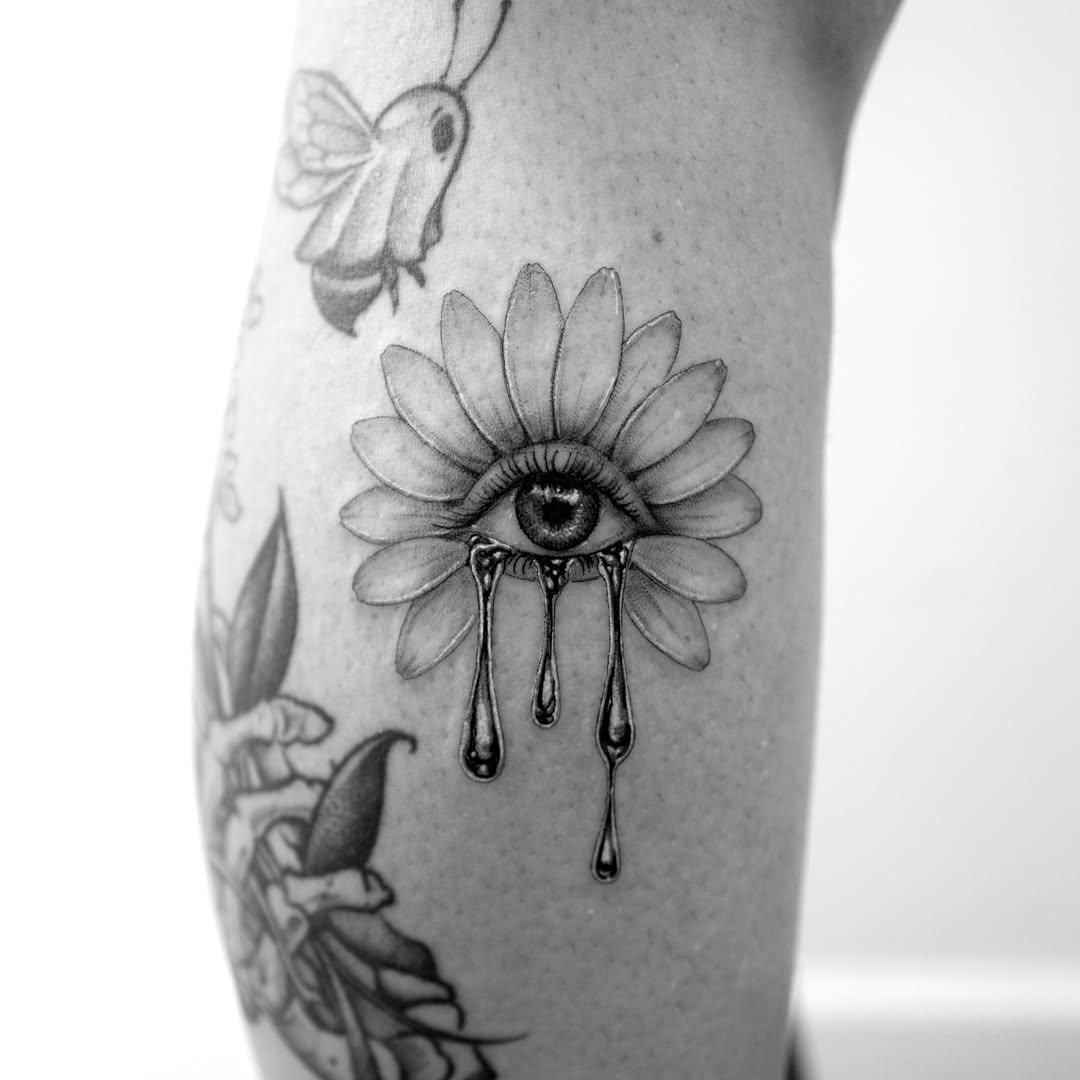 Flower with eye and tears ignorant tattoo on the forearm by Ross Clark Tattoos