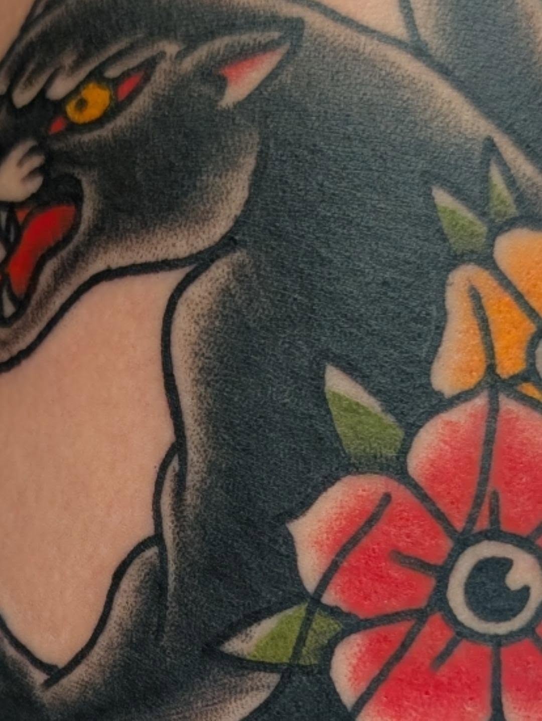 Cat and flower American traditional tattoo on the upper arm by Erik O'Steen, Medford, Massachusetts