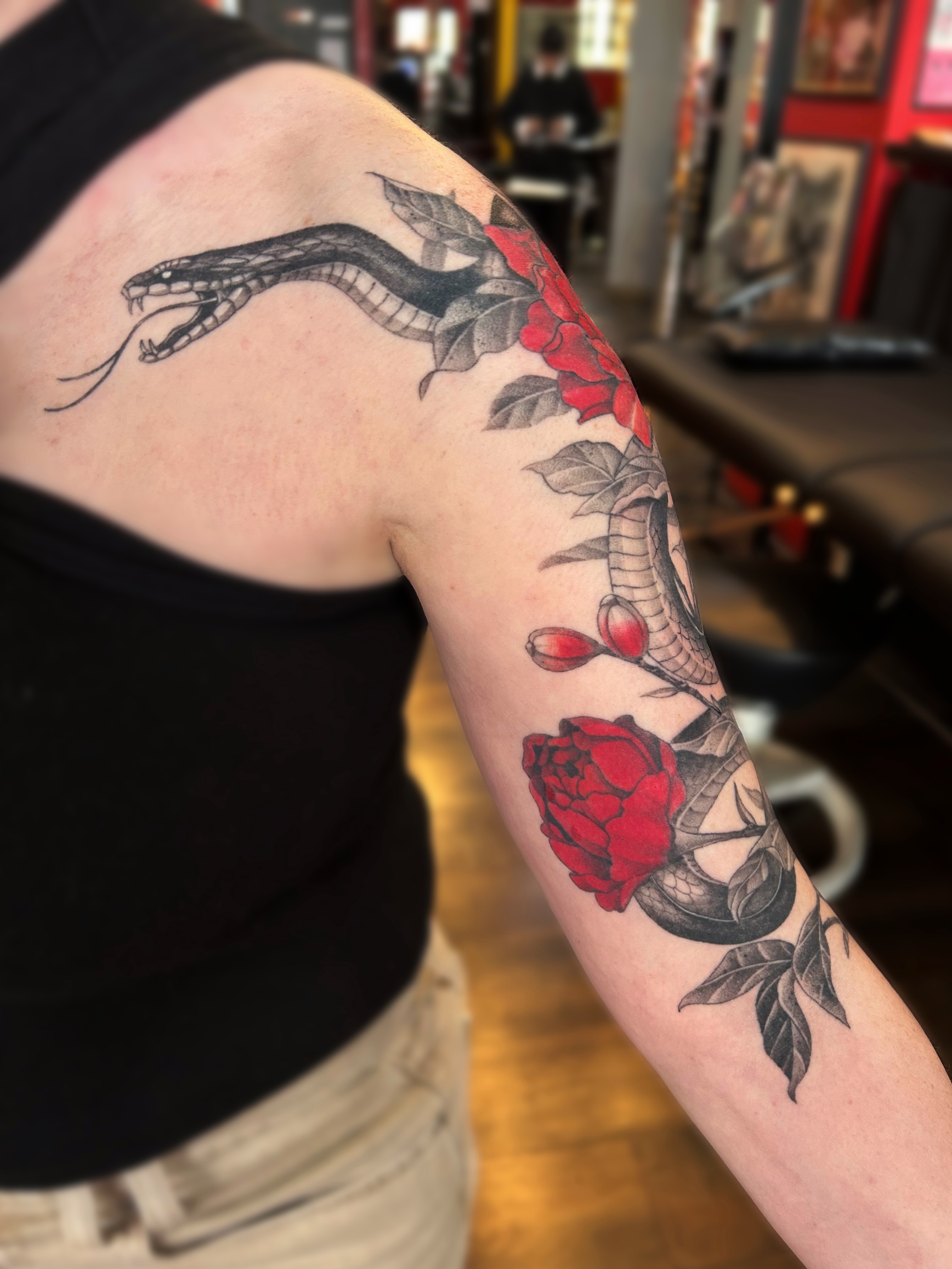 Snake and roses black and grey tattoo on the forearm by Tako, Seattle, Washington