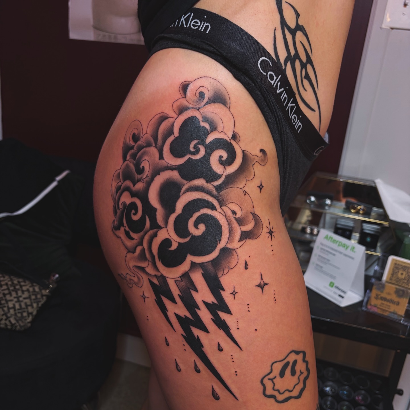 Storm cloud with lightning black and grey tattoo on the thigh by ⚜️Embodied Tattoo⚜️, Columbus, Ohio