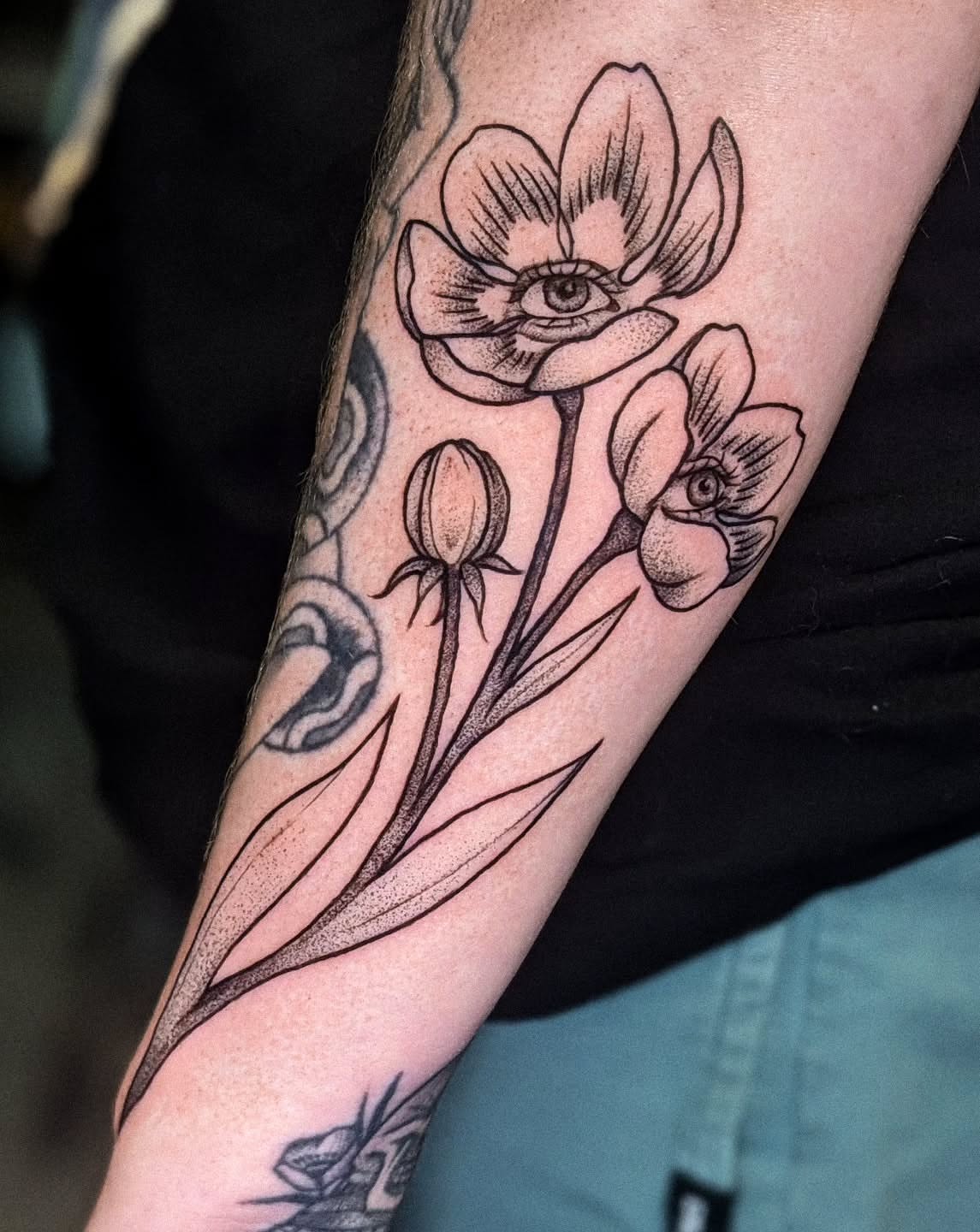 Flowers with eyes black and grey tattoo on the forearm by robin ✨ portland tattoo artist