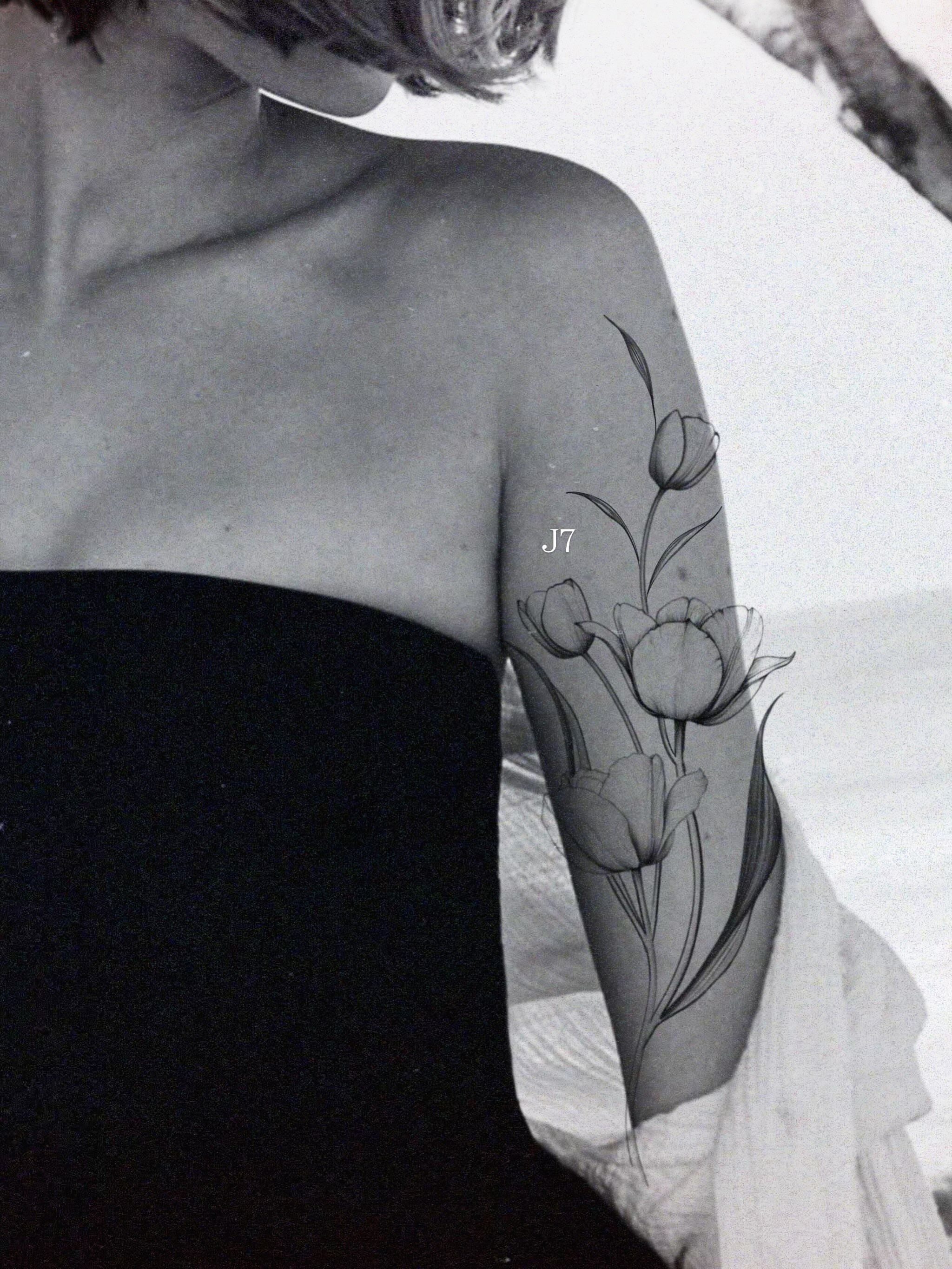 Tulips black and grey tattoo on the forearm by Emma Cotter