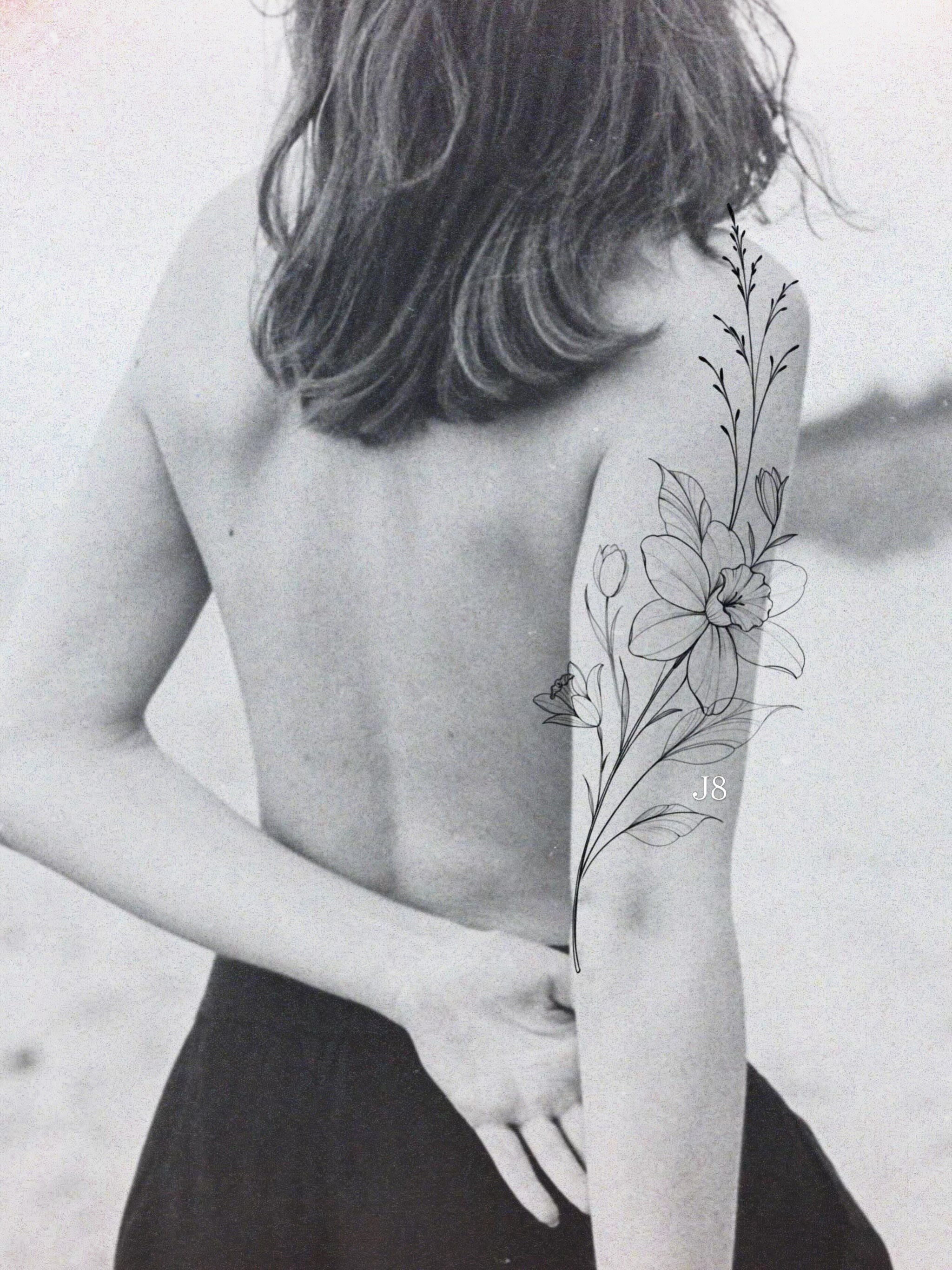 Floral design black and grey tattoo on the upper arm by Emma Cotter