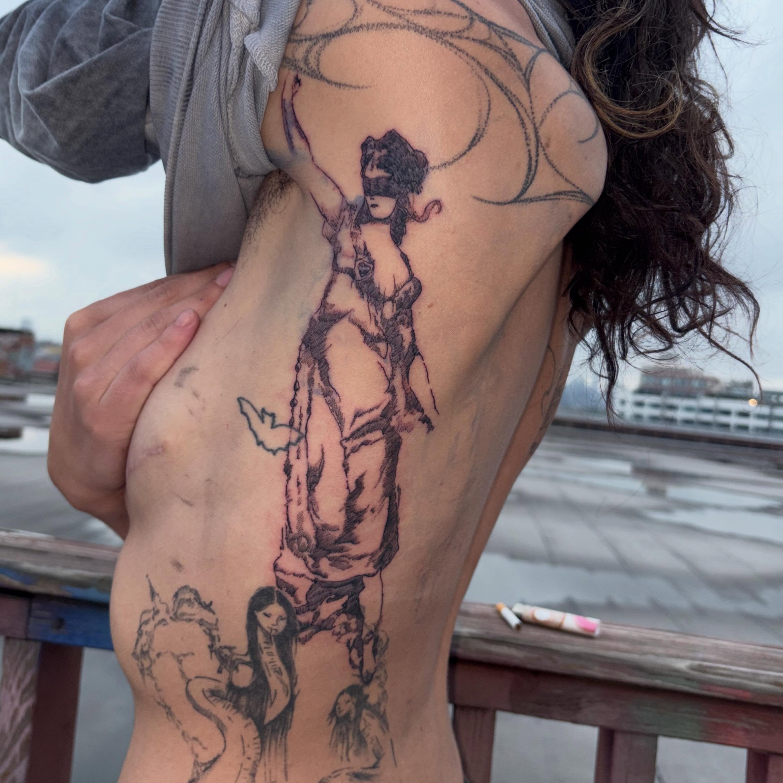 Woman with blindfold black and grey tattoo on the torso by madeline