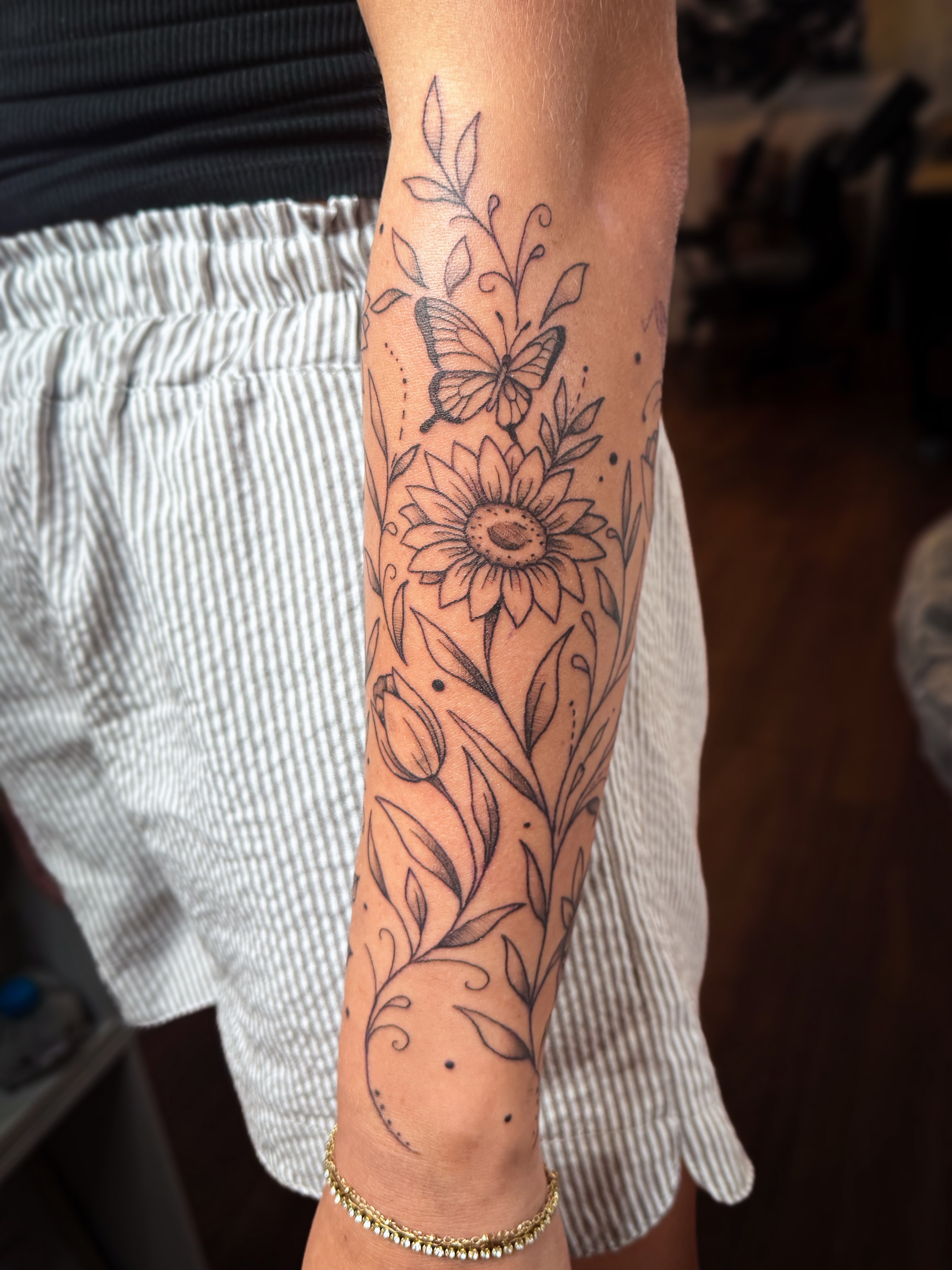 Sunflower and butterfly black and grey tattoo on the forearm by Ash✨