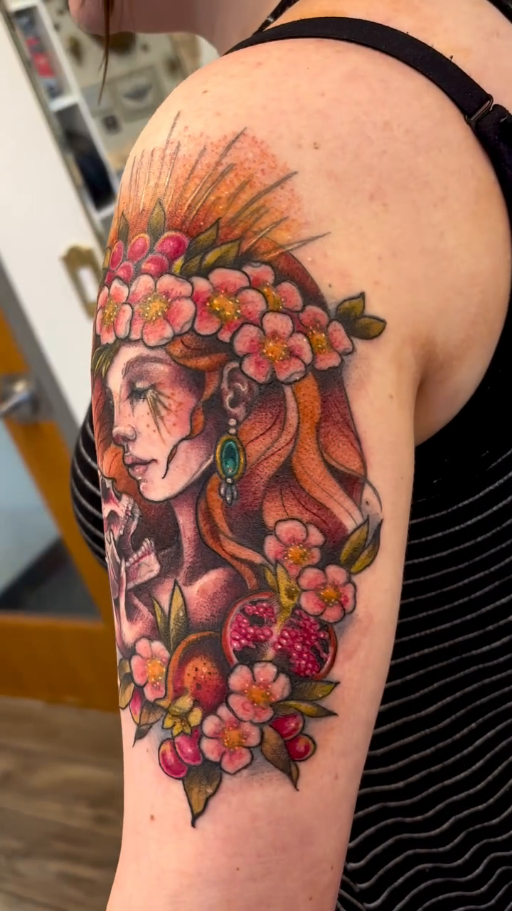 Woman with skull and flowers neo-traditional tattoo on the upper arm by Cricket Elijah Cervidae