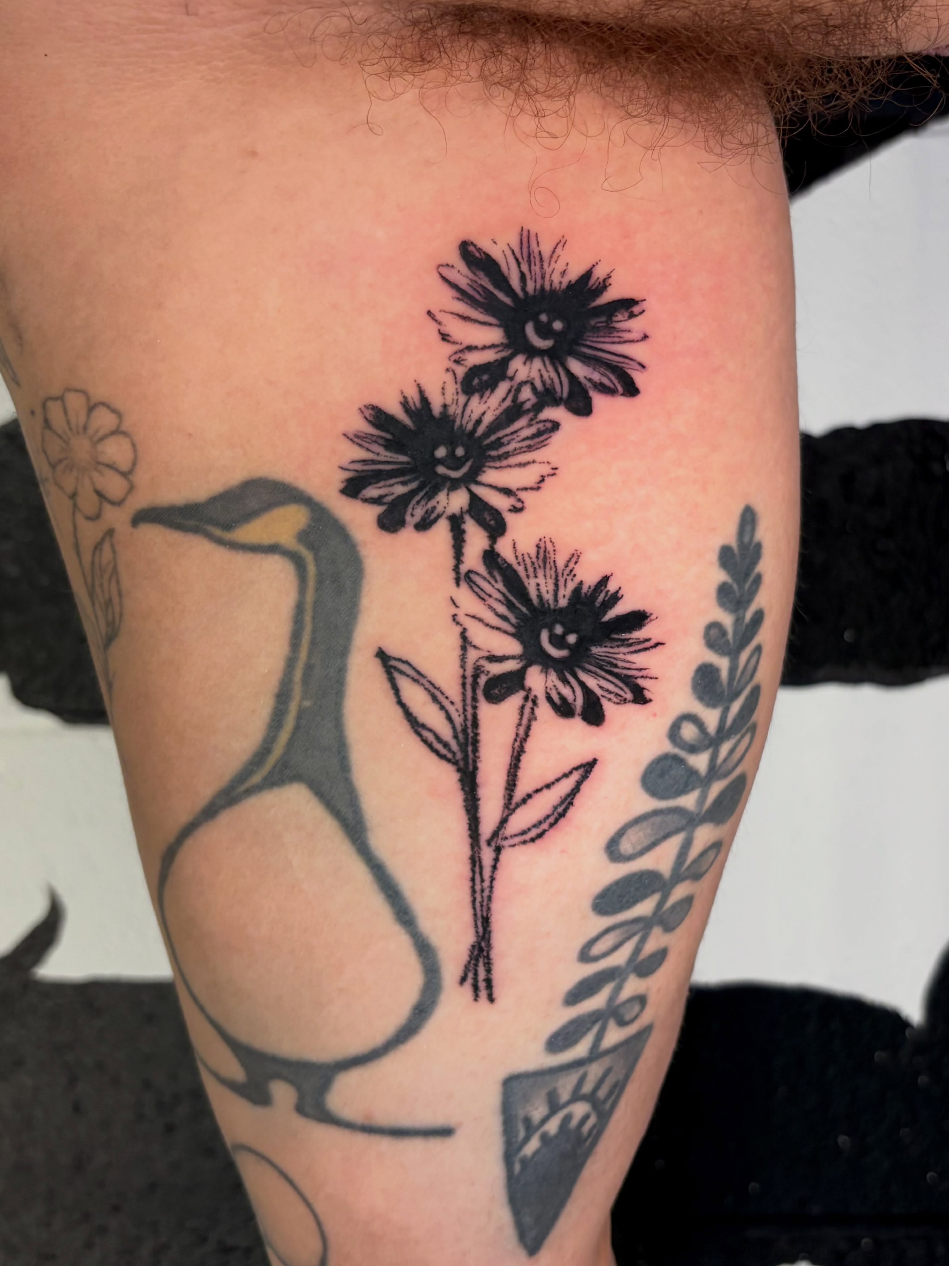Flowers and penguin black and grey tattoo on the thigh by @lil_stinker_5000, Portland, Oregon