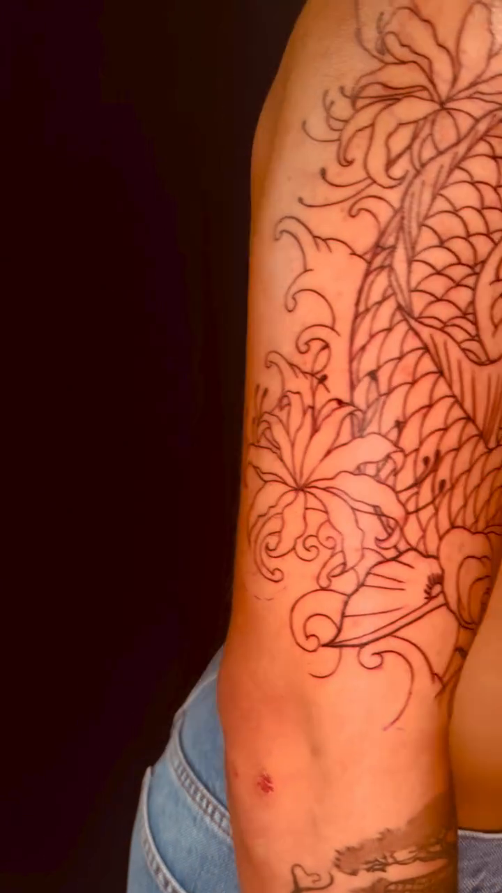 Koi fish and floral sleeve Japanese tattoo on the upper arm by Erik Pagtakhan