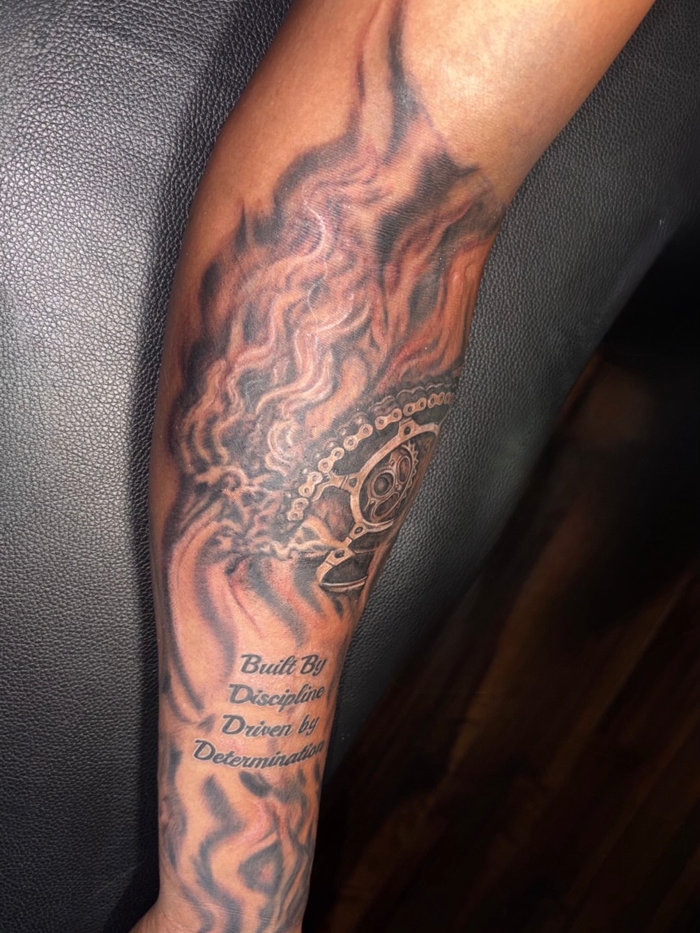 Flames and gear realism tattoo on the forearm by K.L Tattoo Uptown