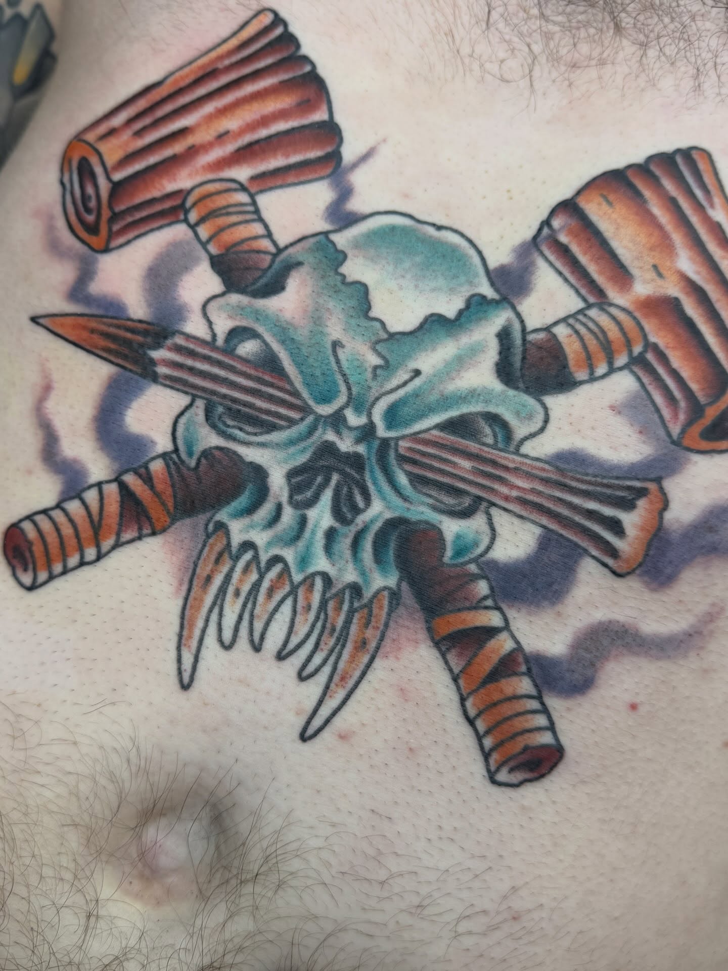 Skull and crossed hammers American traditional tattoo on the chest by Trent Parsley