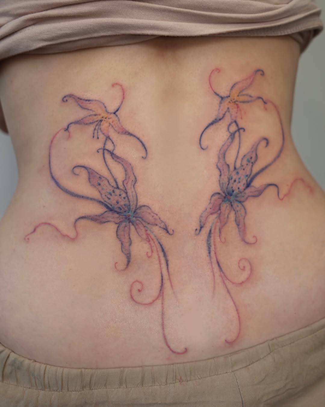 Lily watercolor tattoo on the torso by @havefun_tattoo