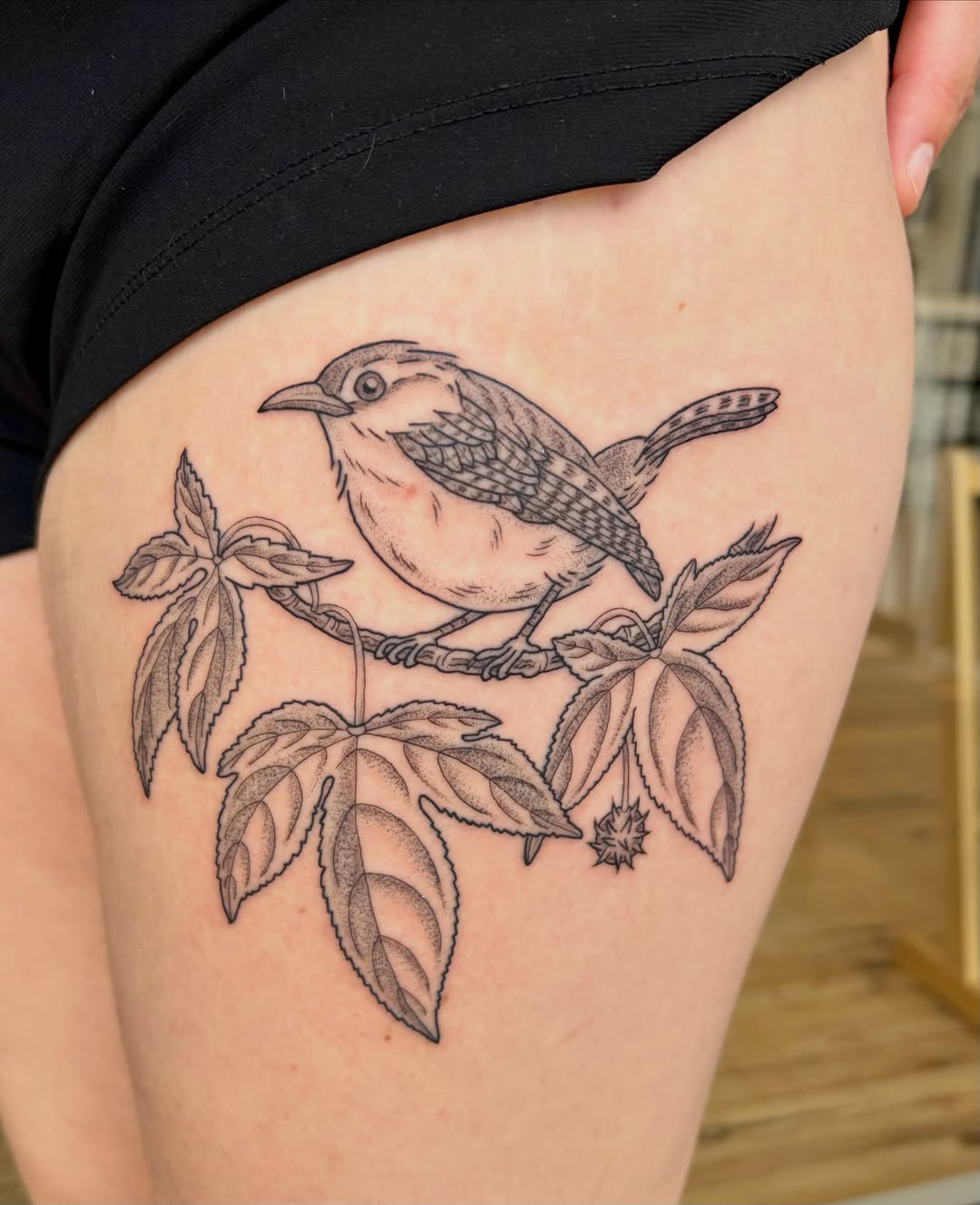 Bird on branch black and grey tattoo on the thigh by Sarah Roach