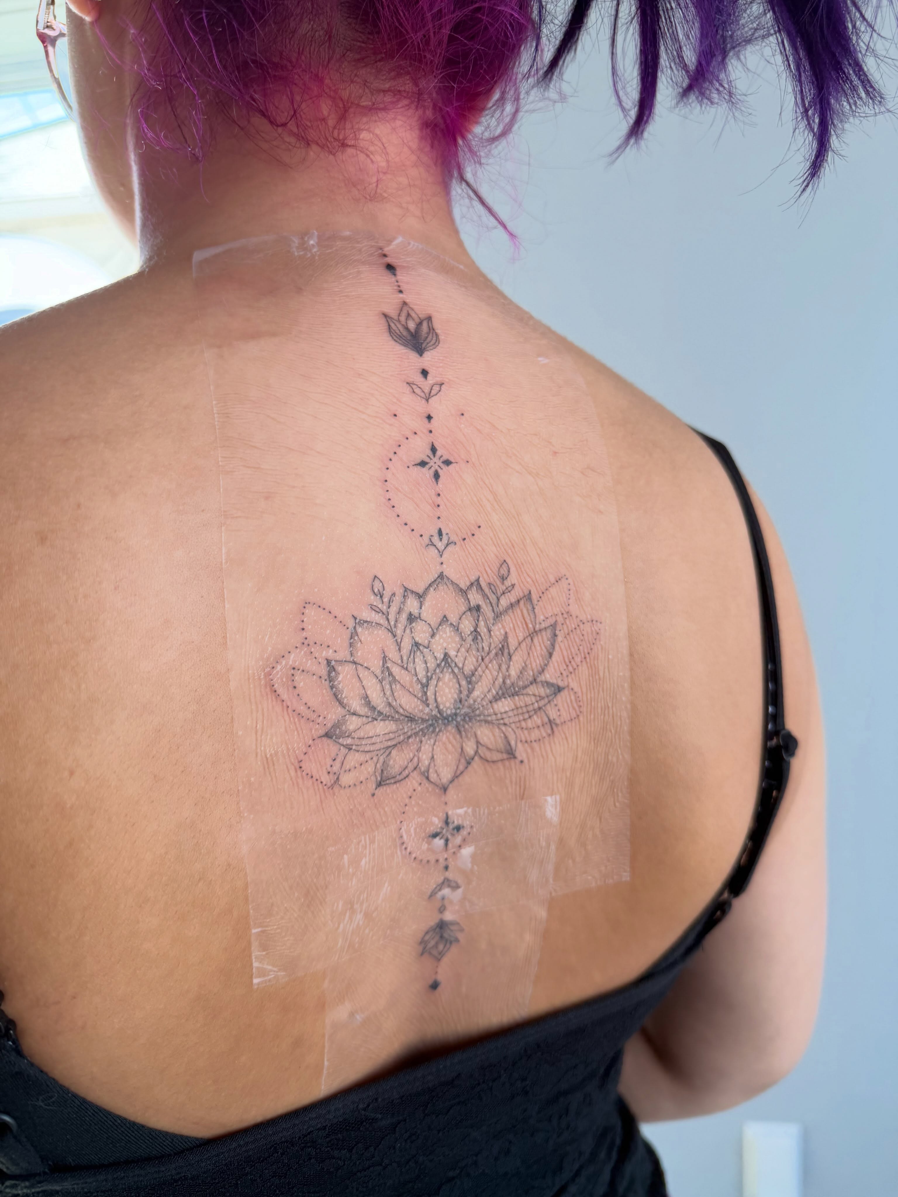 Lotus flower dotwork tattoo on the back by Silva Wellen