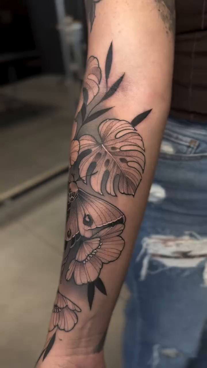 Floral and moth design dotwork tattoo on the forearm by Srey Grace