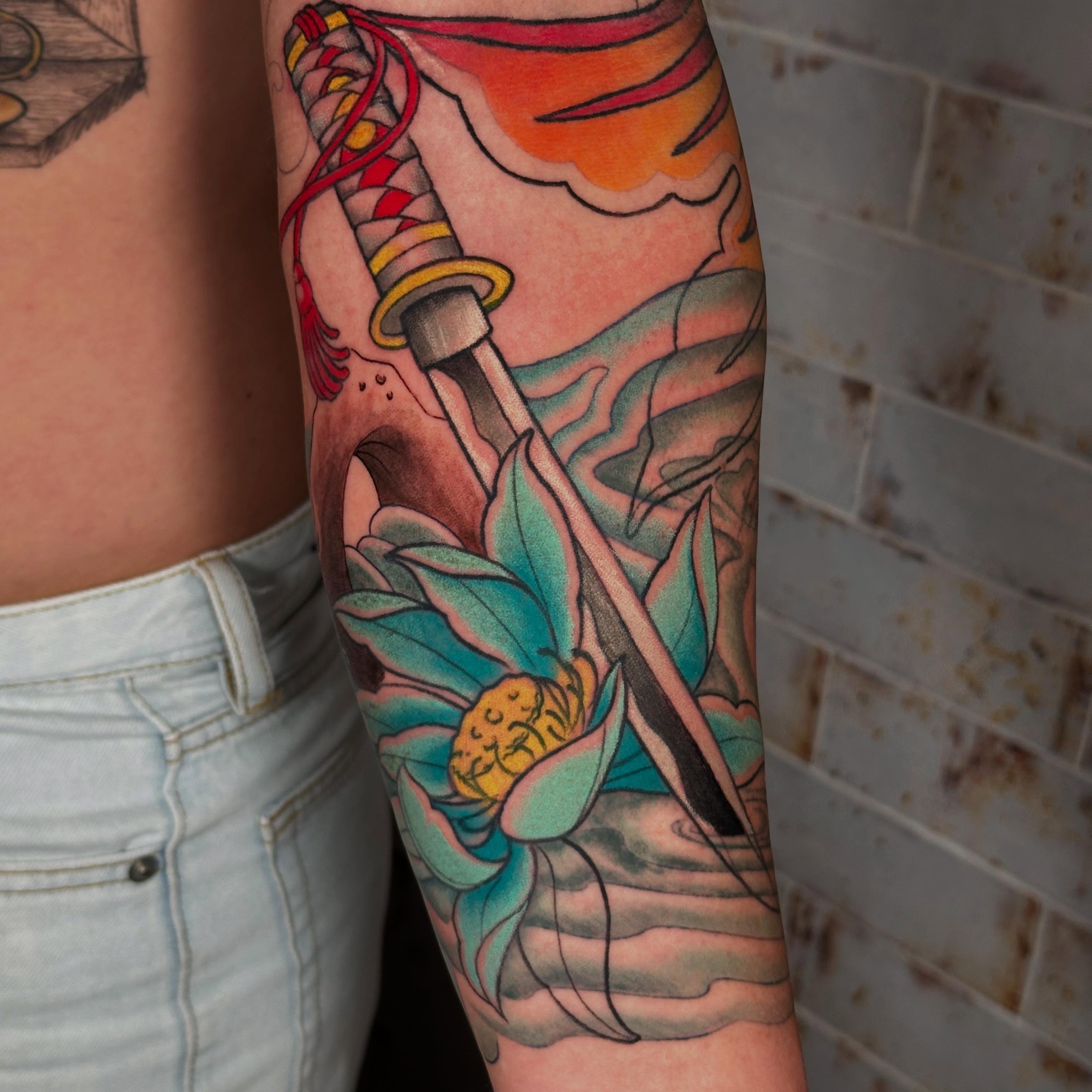 Lotus flower and katana American traditional tattoo on the forearm by Marta La Jirafa