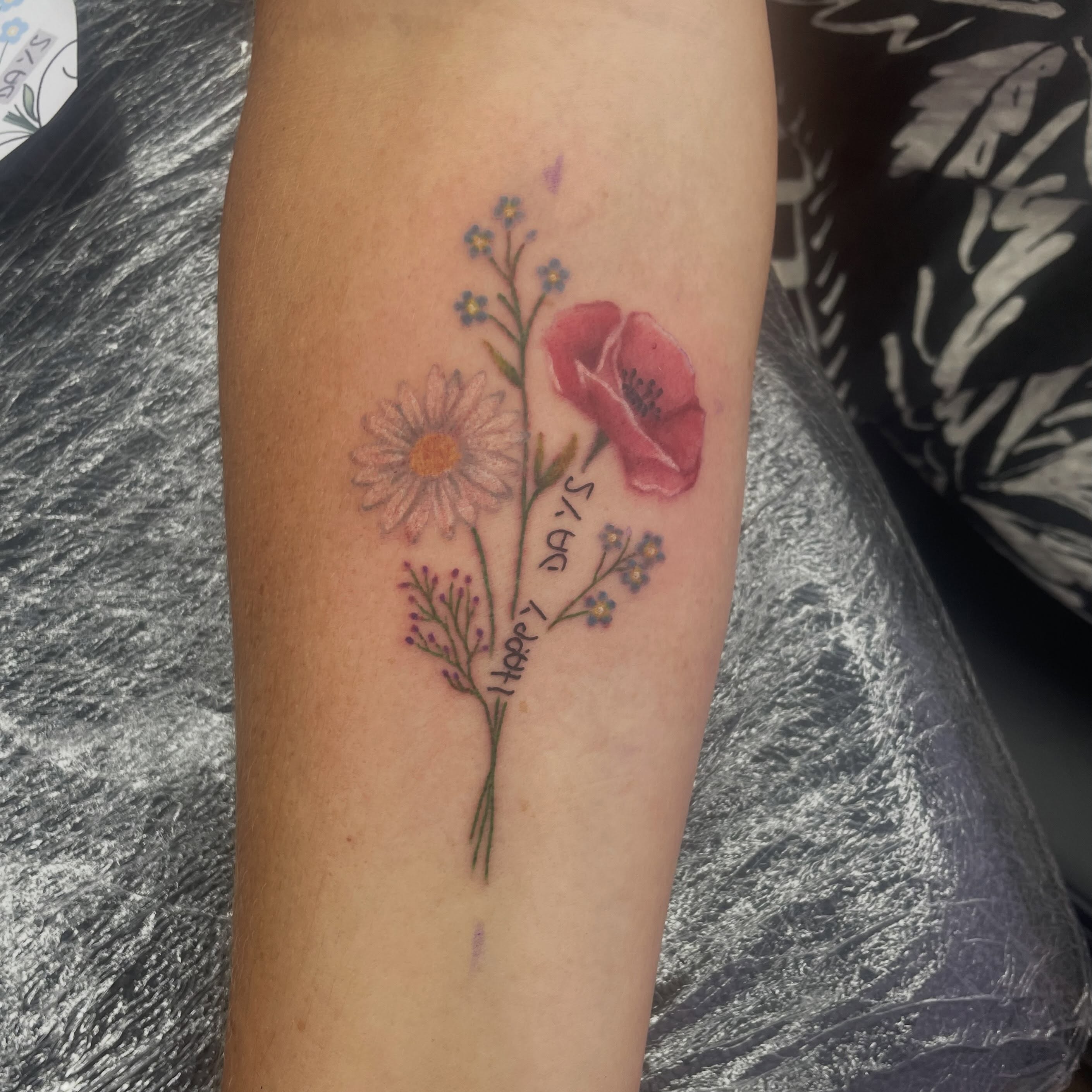 Floral bouquet watercolor tattoo on the forearm by elly, Oakham