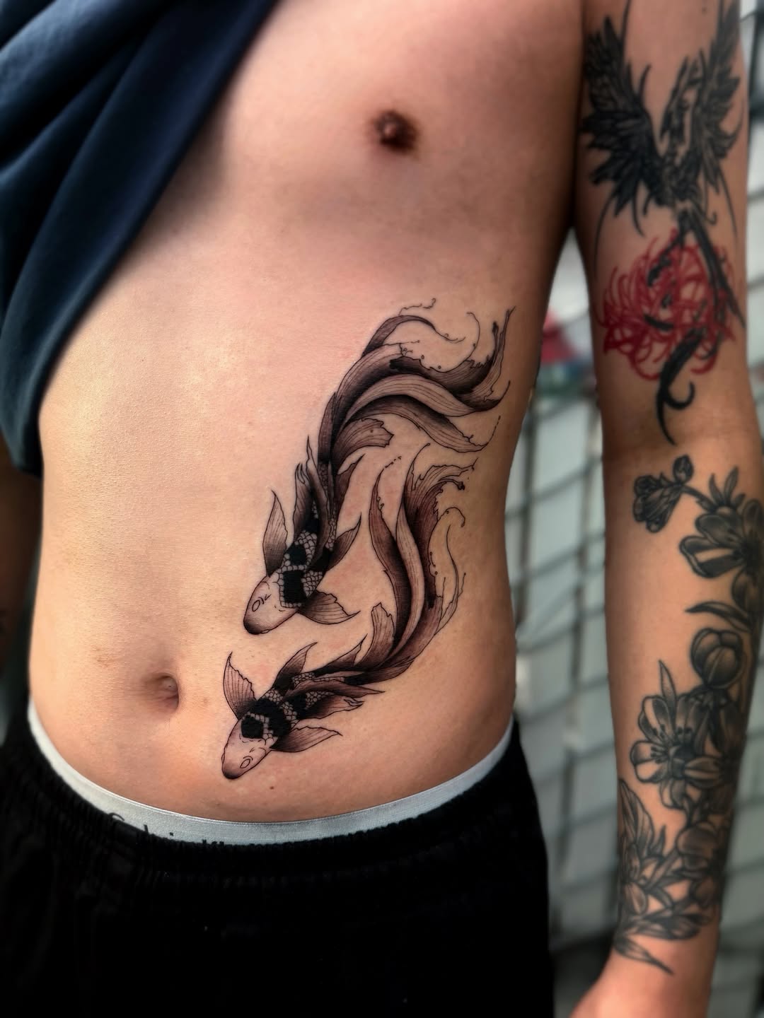 Koi fish fine line tattoo on the ribs by Bryan Nguyen